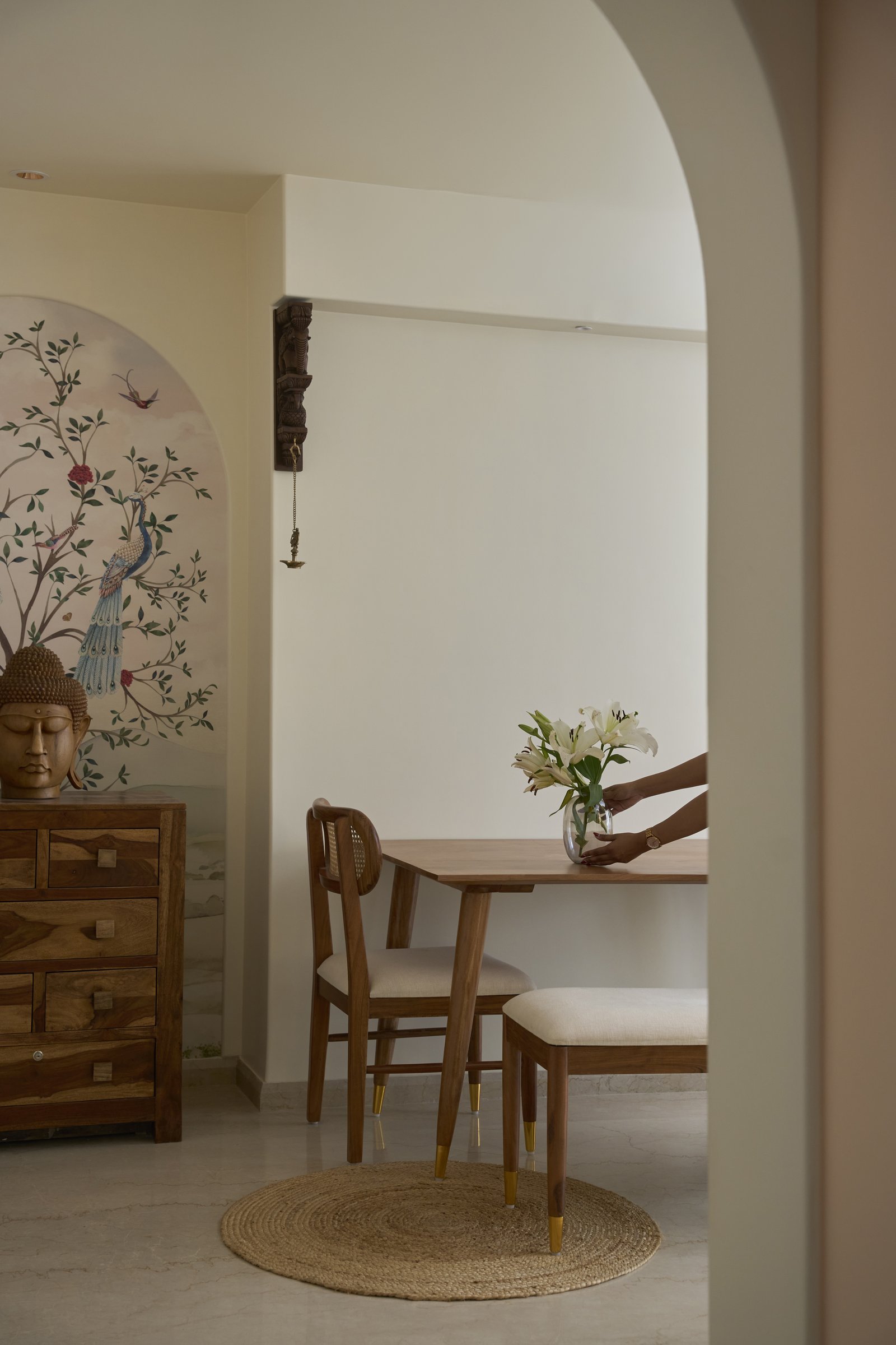Seen through the living room's arched opening, the dining zone reveals how carefully the home's linear axis has been composed
