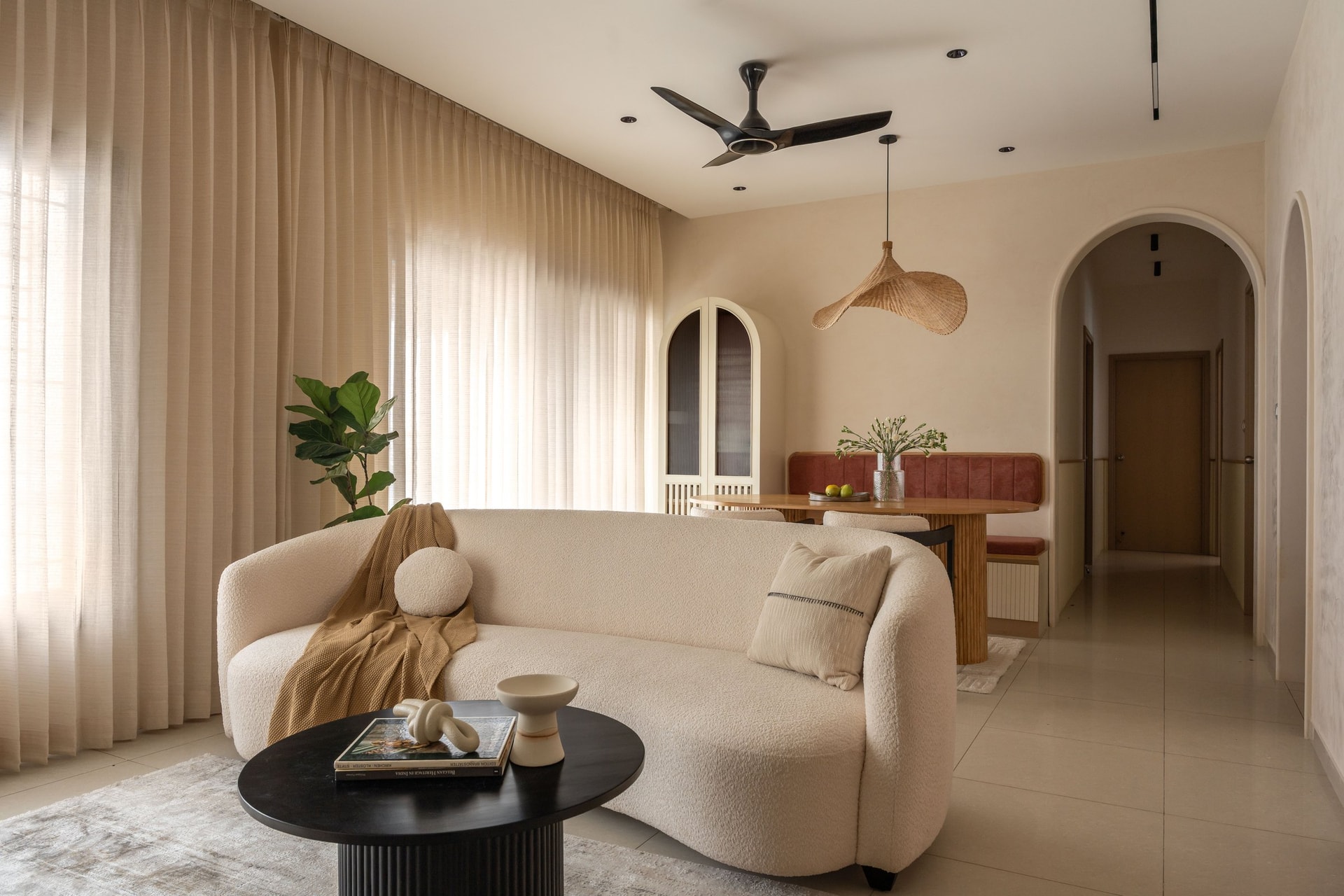 The living and dining volume reads as a single continuous gesture, with arched doorways framing the rooms beyond