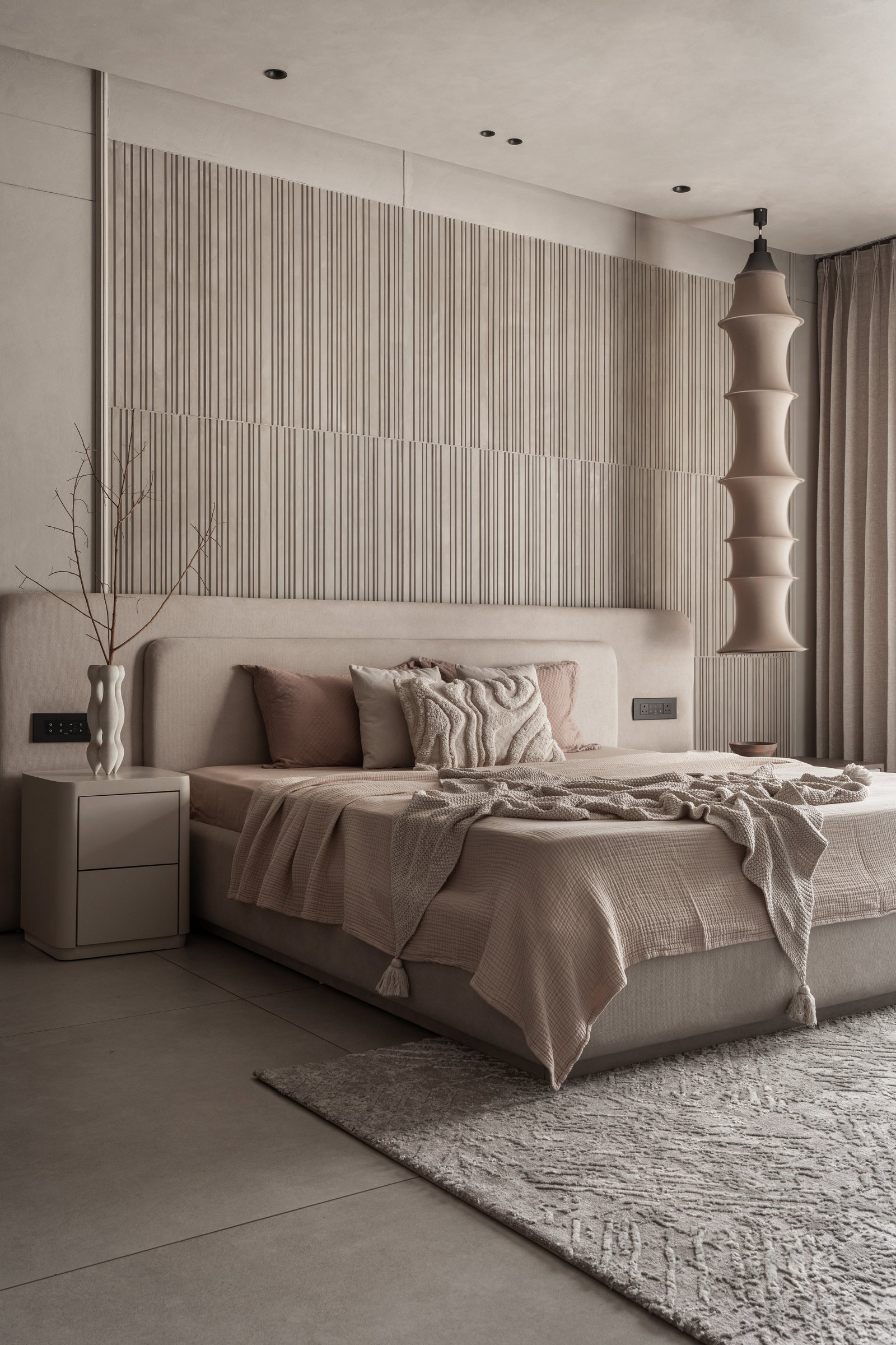 The master bedroom, where the bed is set against a wall of fine vertical reeding broken by a single horizontal band