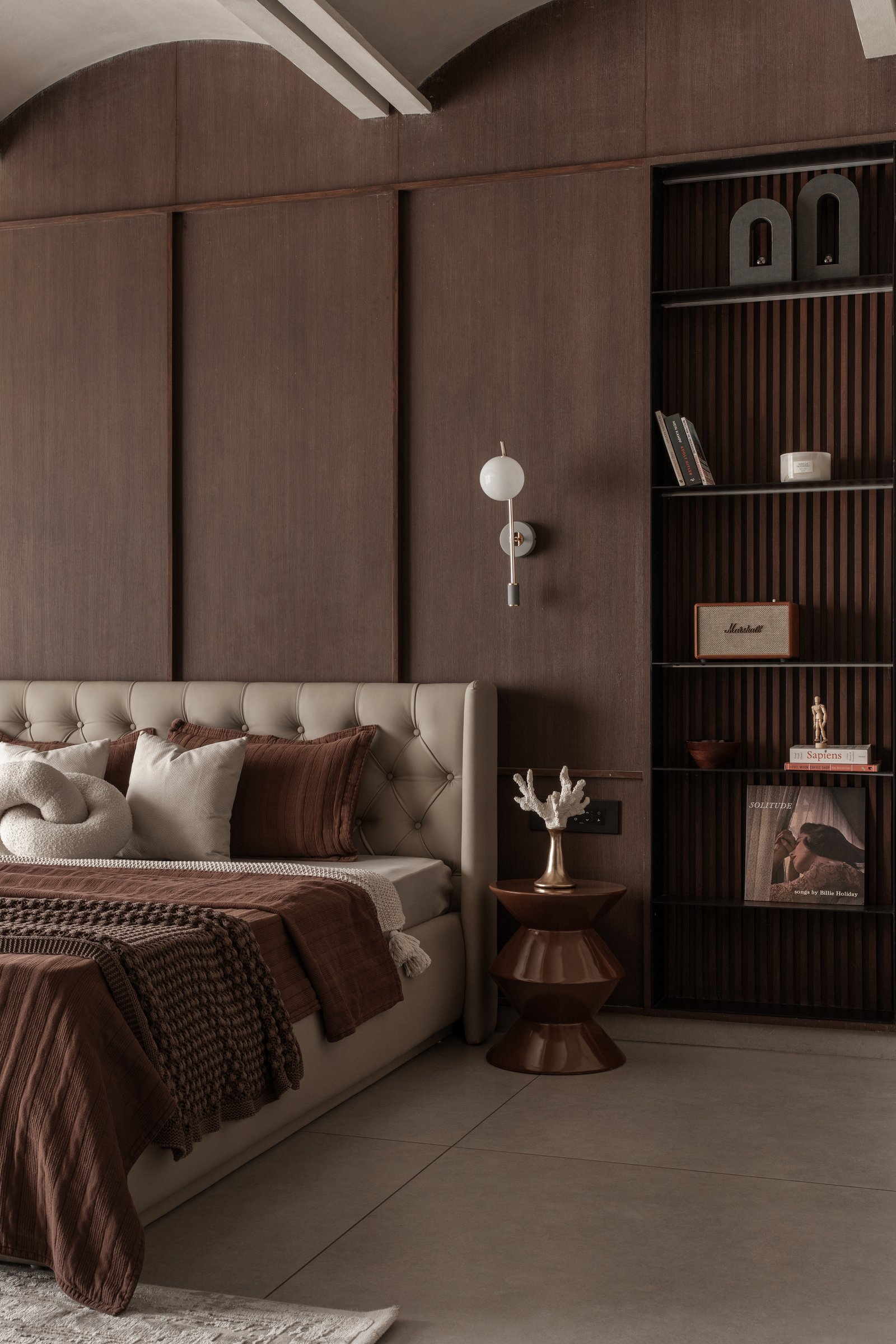 The slatted shelving unit beside the bed, where the family's books and collected objects are finally given room to be seen
