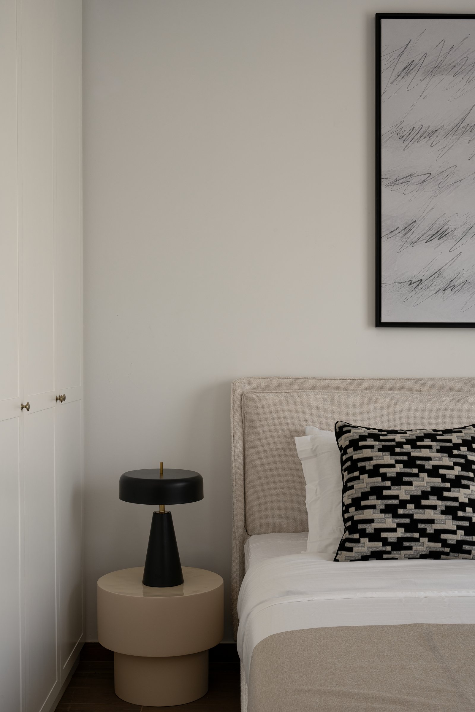 The bedside arrangement: a domed lamp on a sand-toned pedestal, proportioned as a single sculpture
