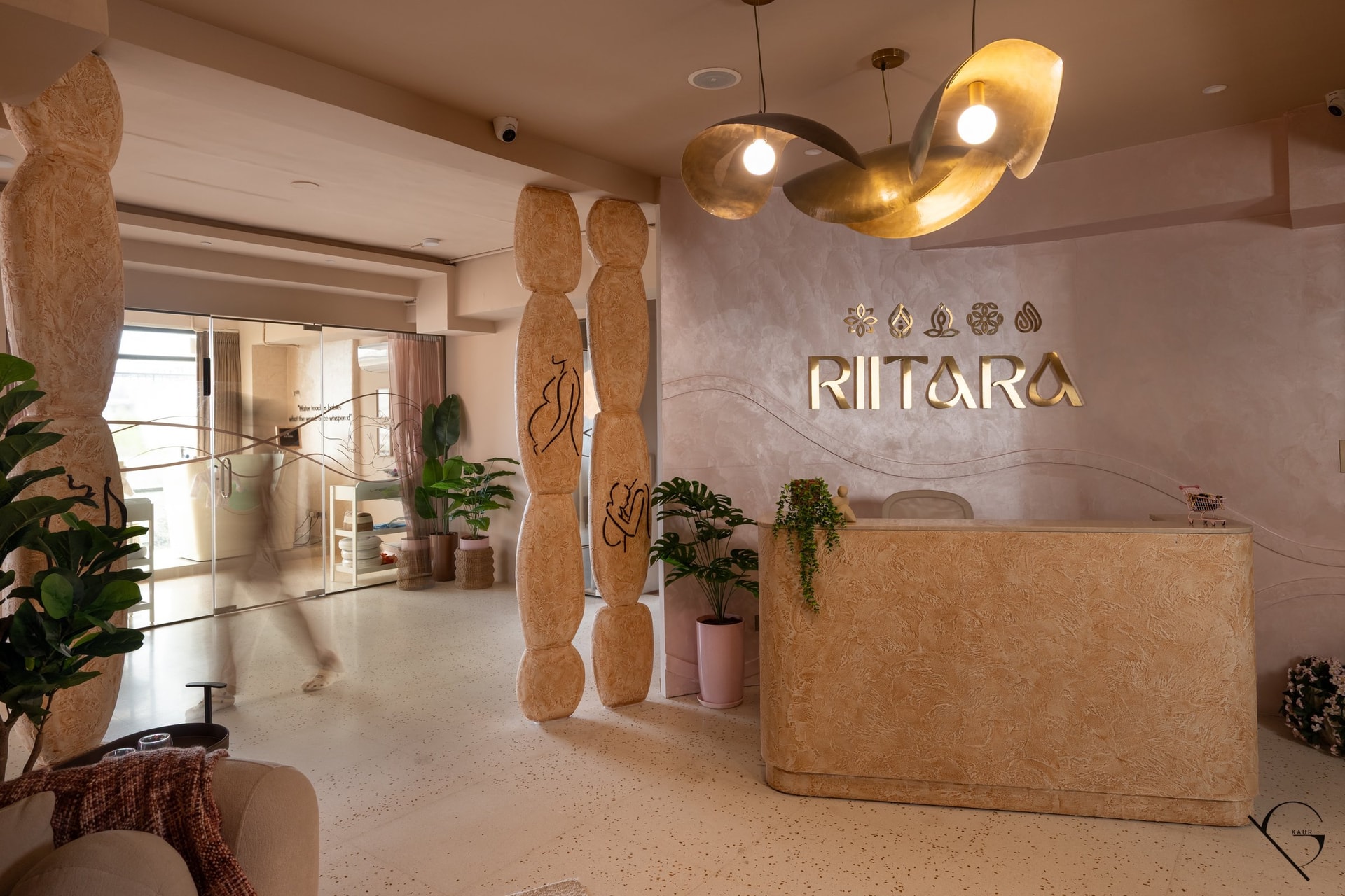 A second view of the entry, where the textured plaster desk and terrazzo floor establish a single continuous material ground