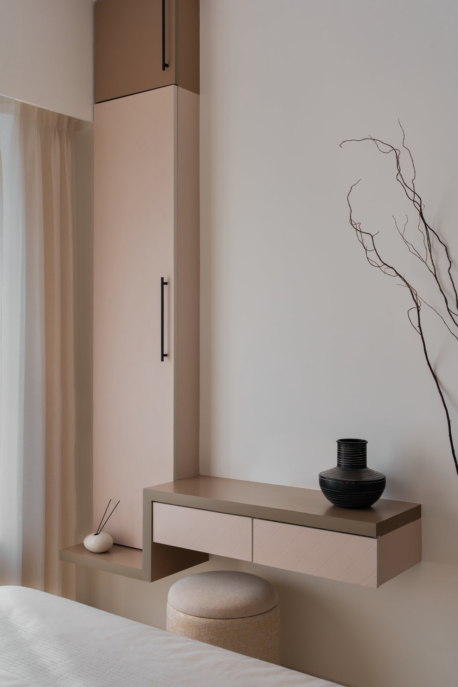 A floating console in muted taupe paired with a tall slim wardrobe in matching finish