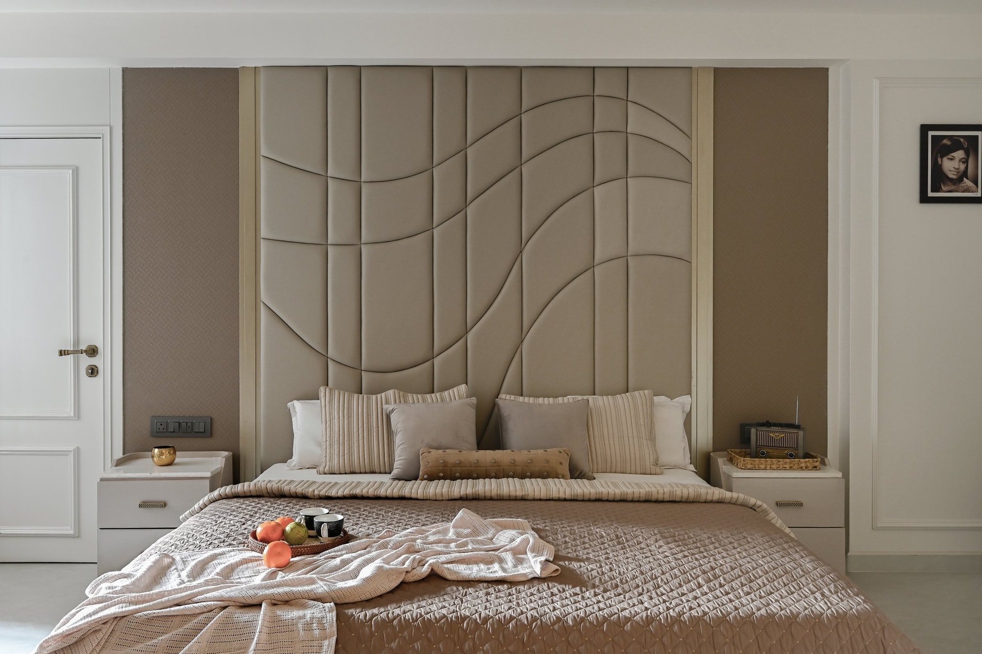 In the master bedroom, an upholstered wave headboard wall is the project's most contemporary moment