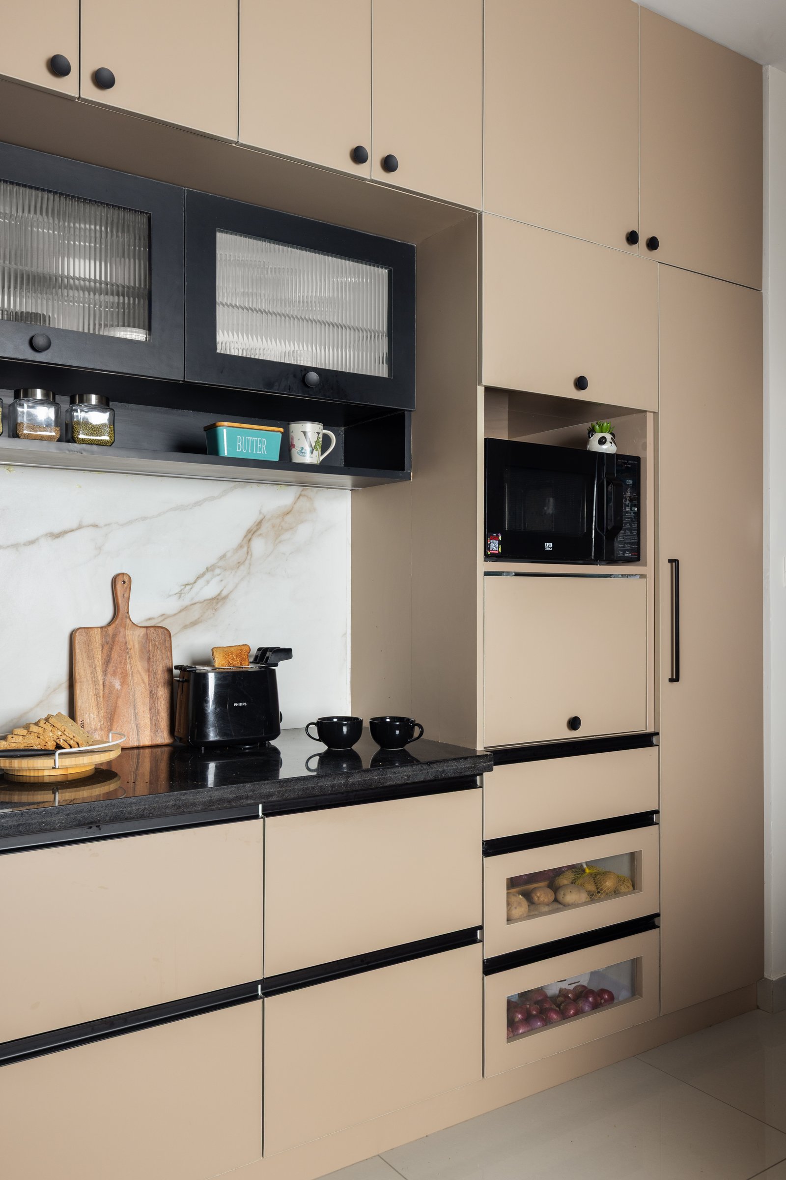 Full-height storage and an integrated microwave niche; open-fronted drawers offer a small piece of honesty in a room built on concealment
