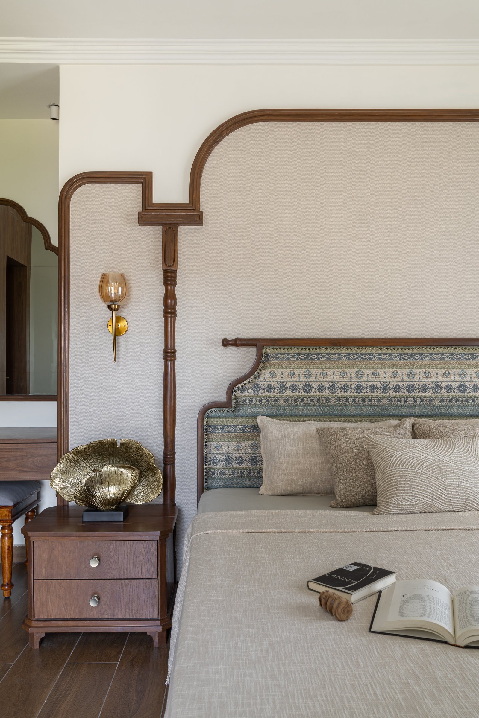 A closer view of the headboard, with its patterned panel, turned post, and amber-glass sconce
