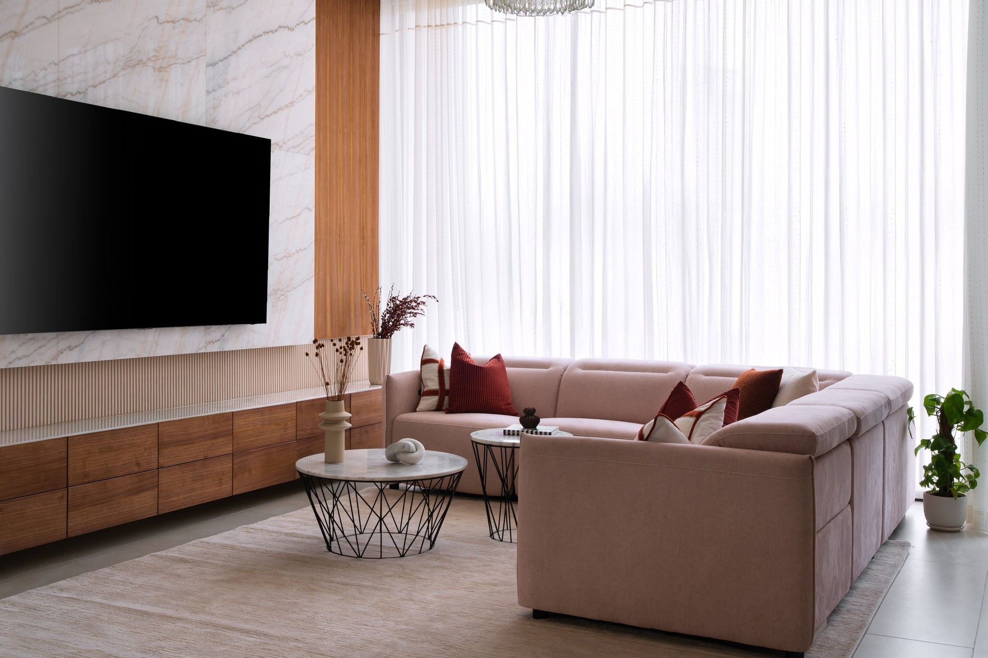 The television wall, where softly veined quartzite and a walnut media console set the room's quietest material conversation