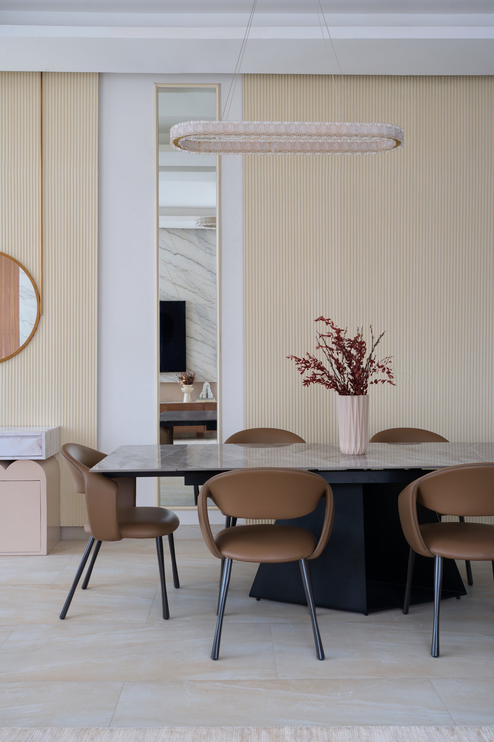 The full-height ribbed dining wall, framed by a slim mirrored insert that opens a sightline back into the living room
