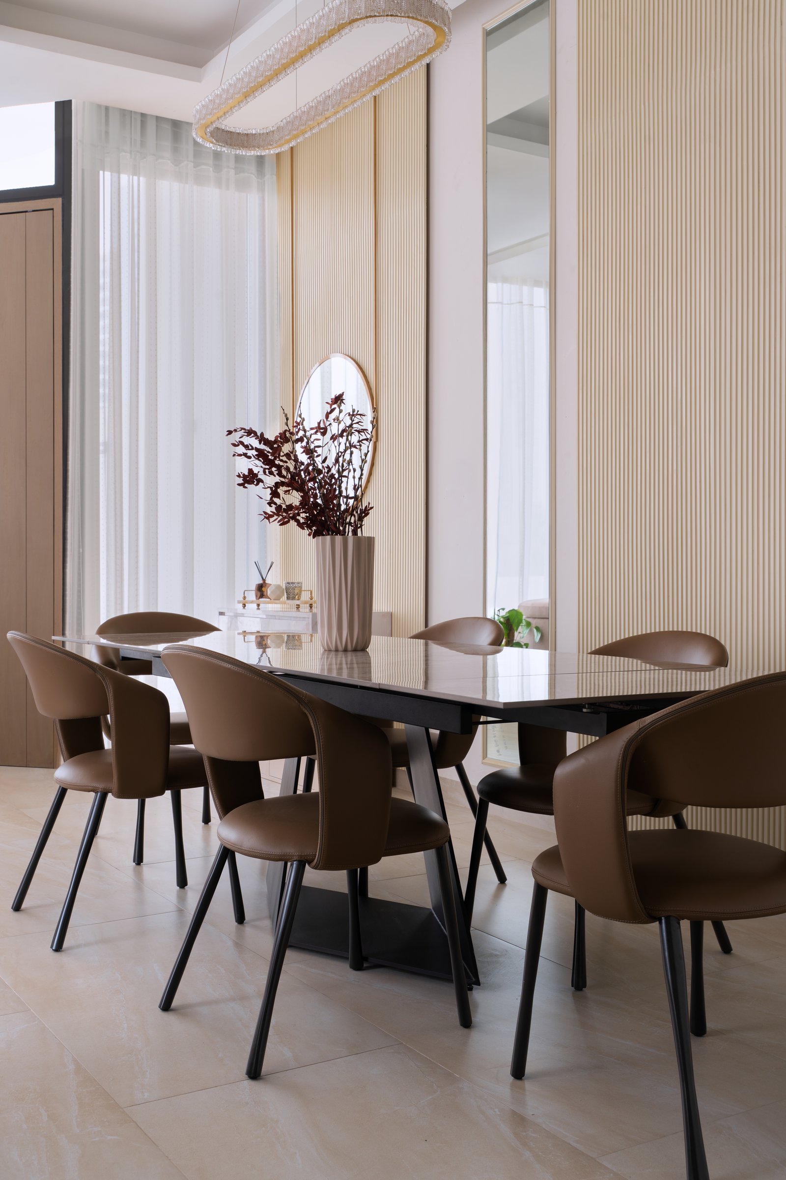 A study in calibrated texture: ribbed cream walls, fluted vase, and caramel leather chairs all within half a tonal step