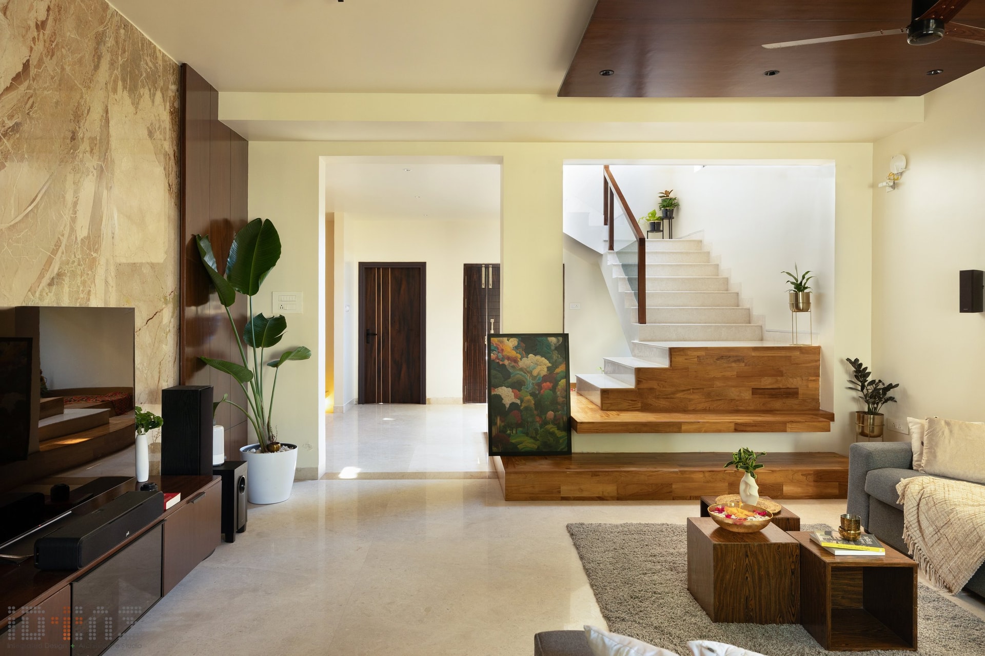 The living room's stepped wood platform doubles as informal seating and a transition into the upper floor