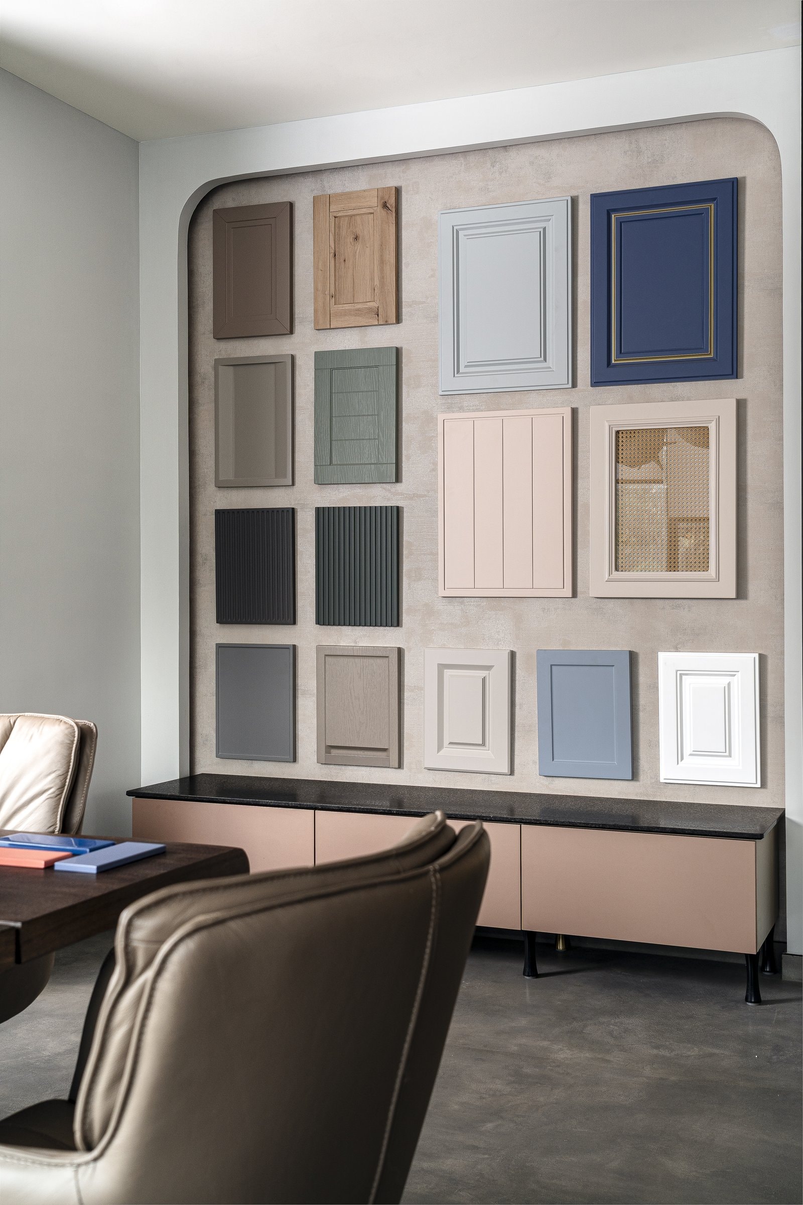 The sample wall, an arched plaster recess hung with shutter panels in the studio's working palette