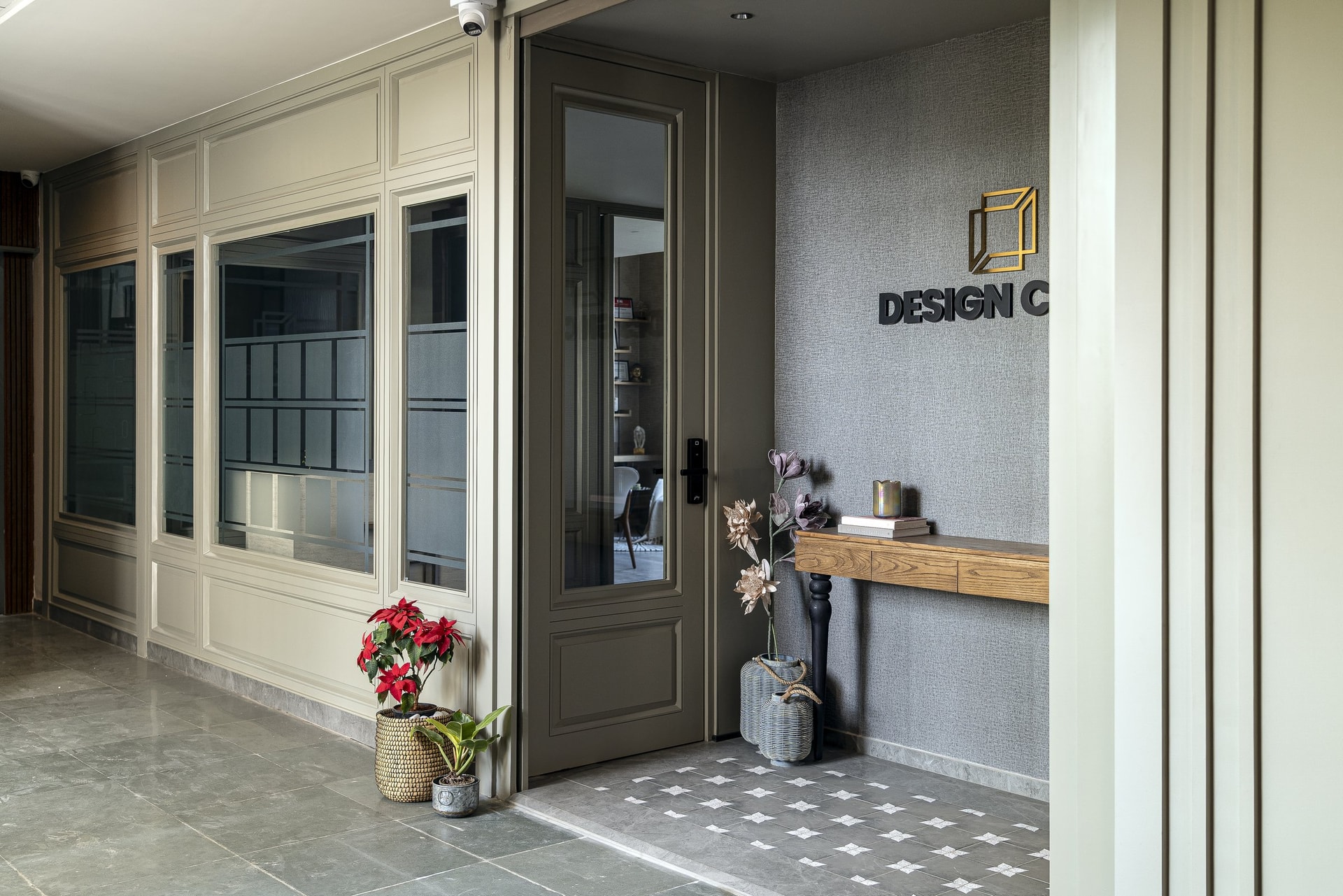 The arrival: classical panelling, glazed inserts, and a patterned stone threshold establish the studio's tone before the door opens