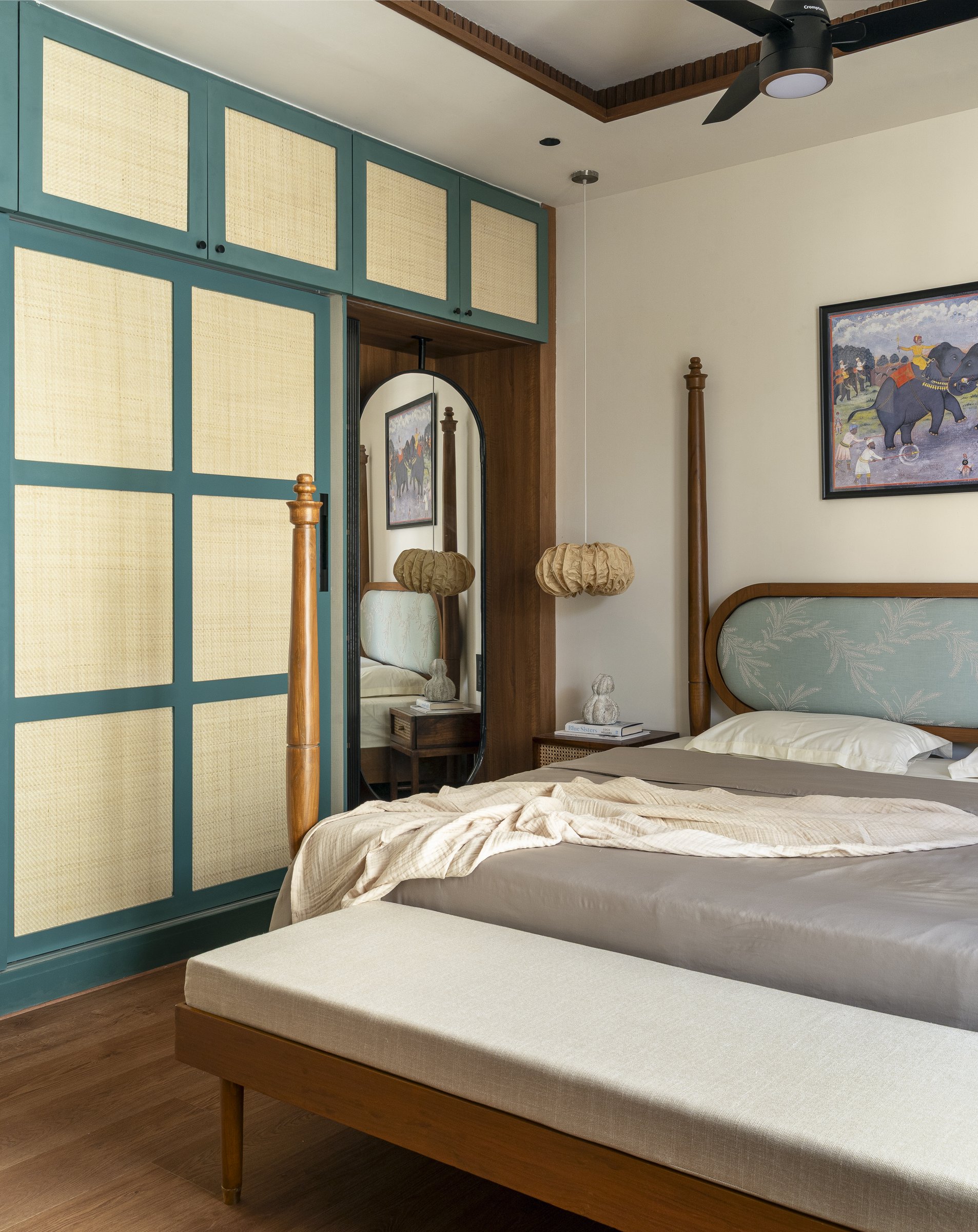 The wardrobe wall in the master, where bluish-green frames hold woven rattan panels, a contemporary refit of the old Madras cane almirah