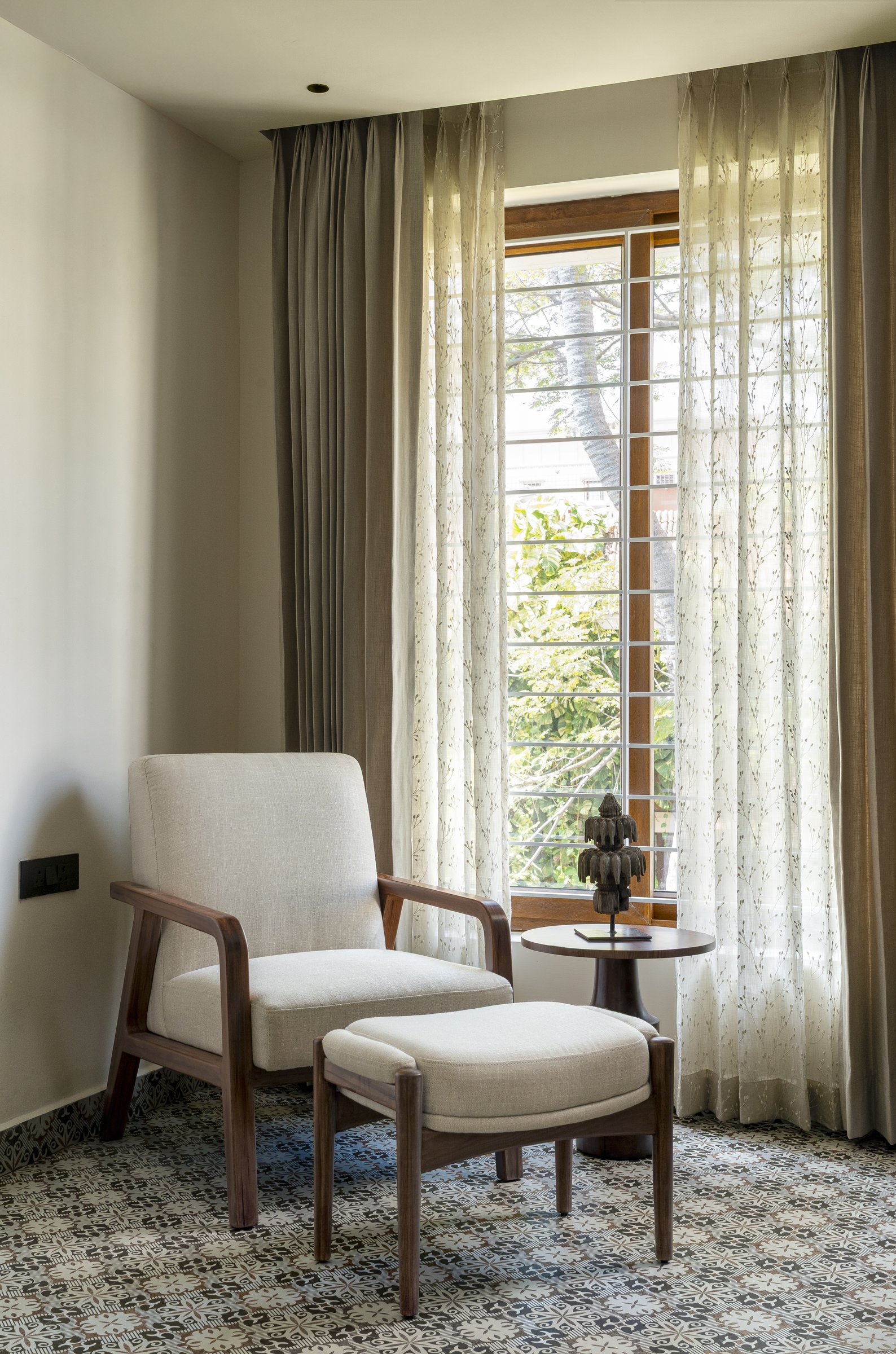 A lounge chair and ottoman by the study window, the home's most literal answer to the couple's brief for a place to come back to