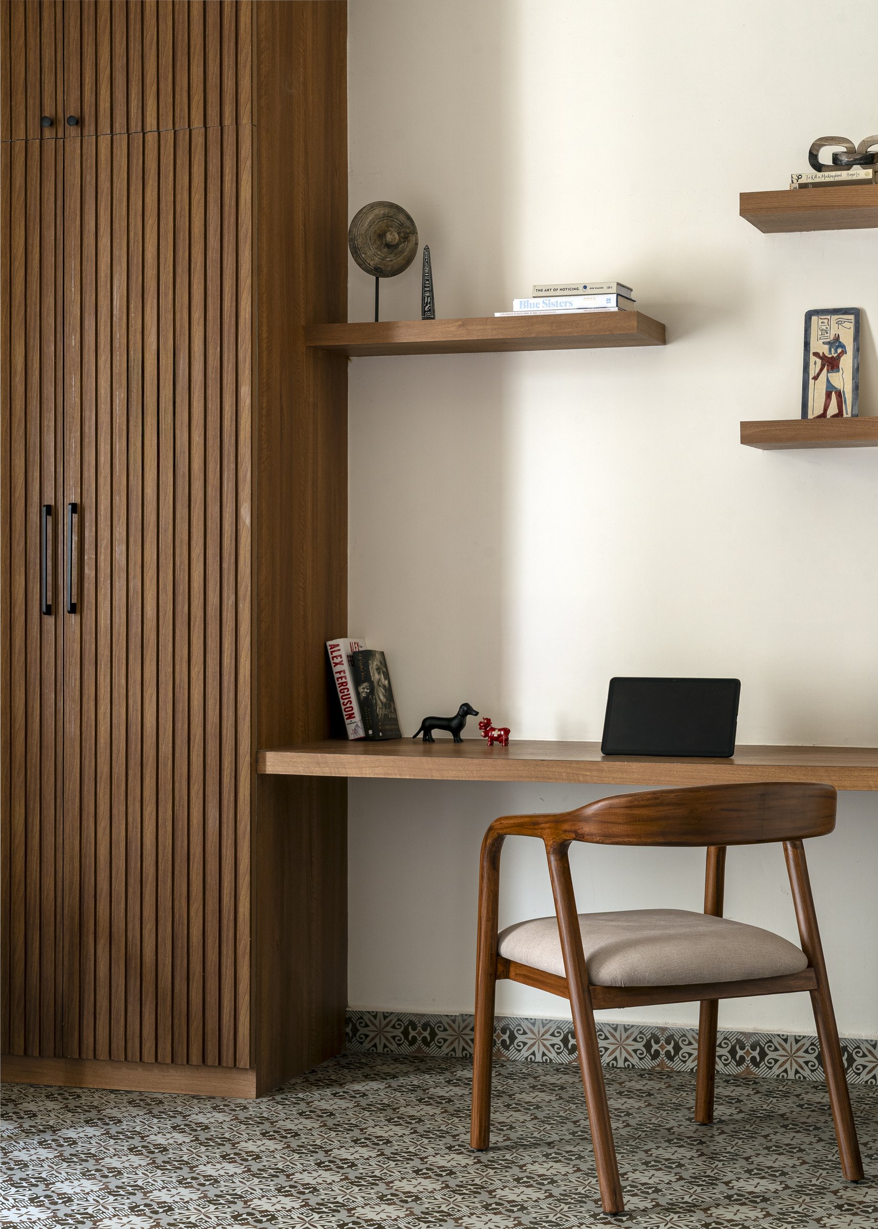 The dedicated study, where dense geometric cement tiles and a fluted wood-grain wardrobe lend the room the atmosphere of a heritage Madras flat