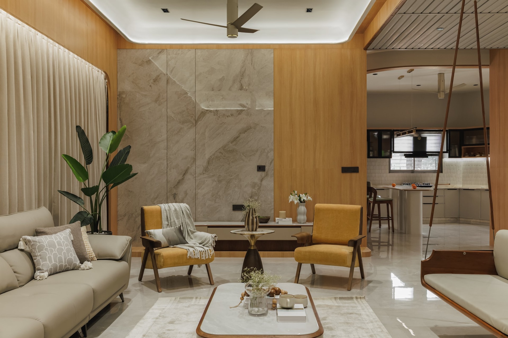The living room opens off the central spine, with mustard yellow chairs introducing the home's single chromatic argument