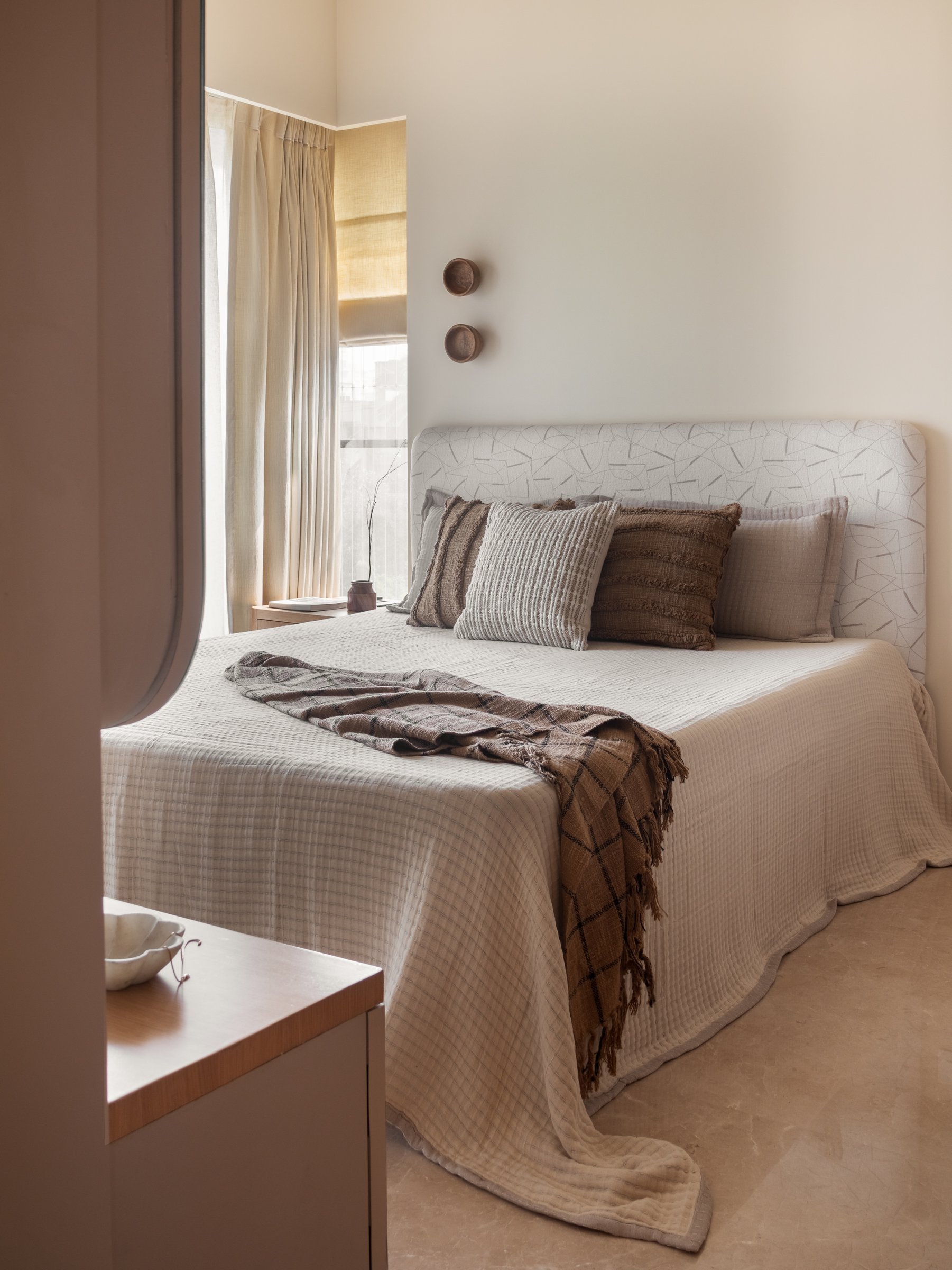 The master bedroom, where a sesame-seed wall tone wraps the room into a single cocooning envelope
