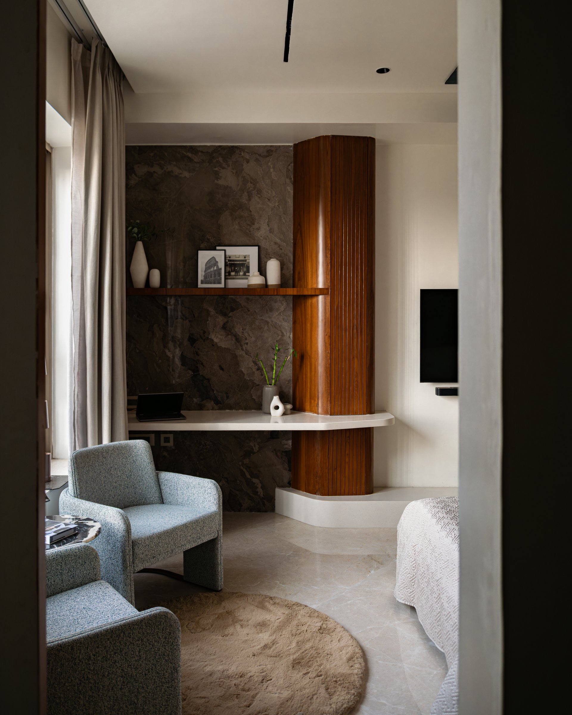 Within the master suite, a fluted teak column wraps a structural element beside a cantilevered study ledge