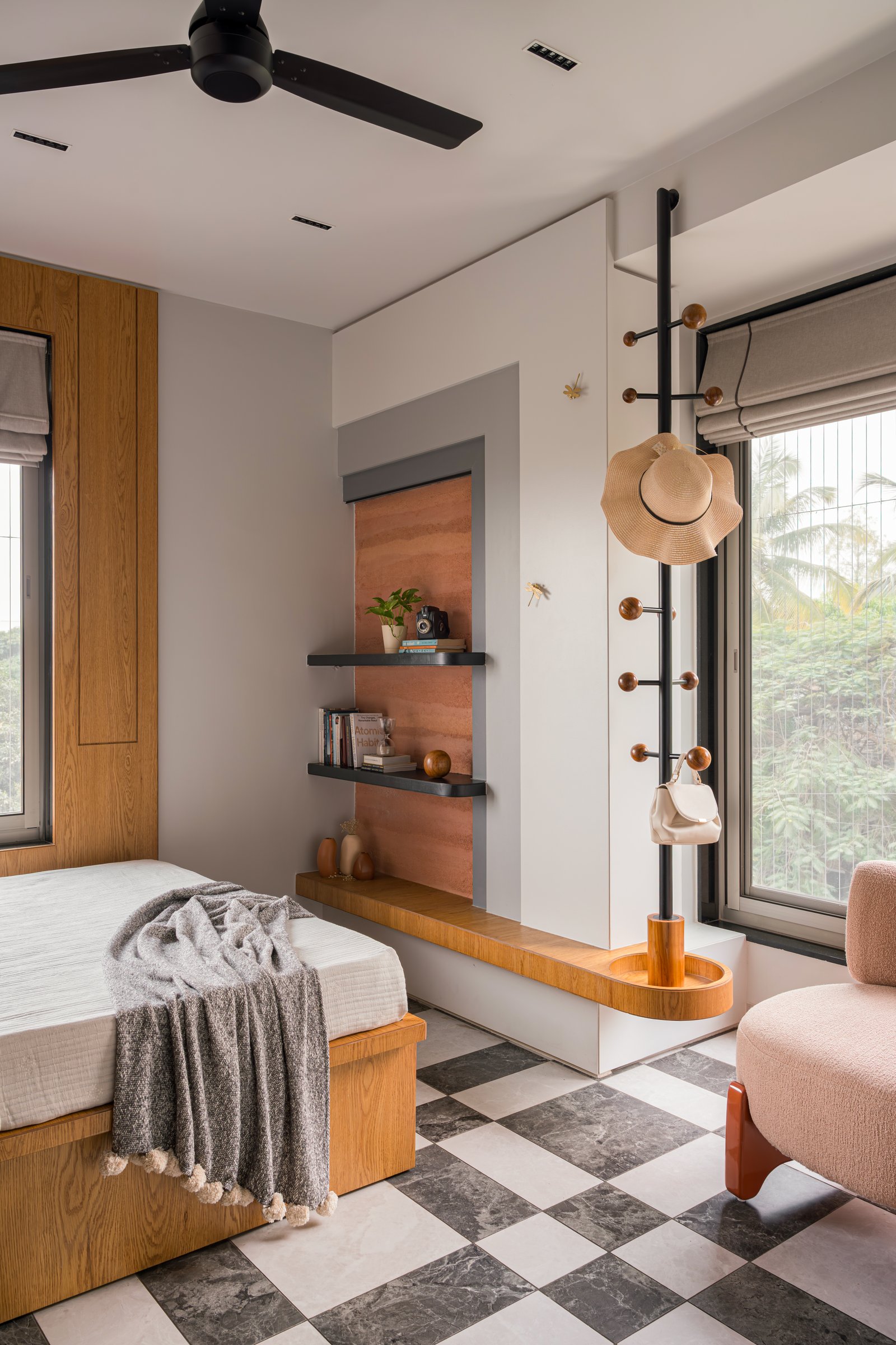 The second bedroom: a checkerboard floor, a wood-framed niche, and the project's first hint of playfulness