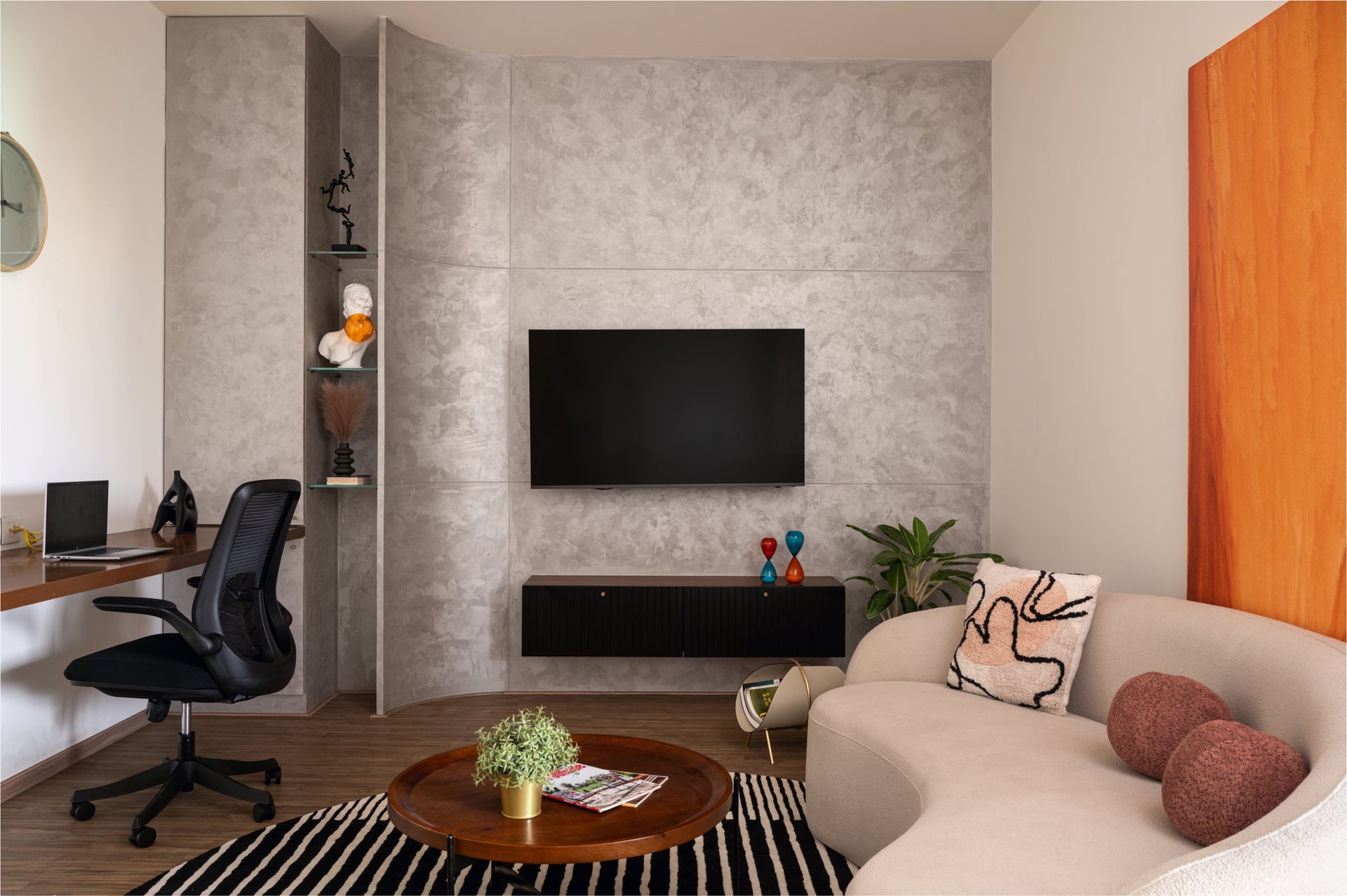 The upper-floor living room, conceived as a flexible space that holds work, display and lounging within a single curved envelope