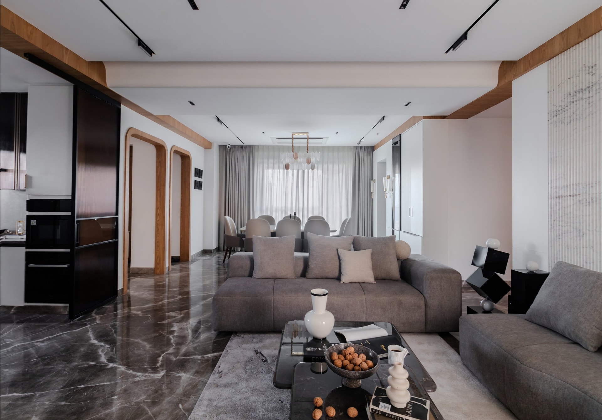 The living room opens into the home's principal volume, framed by a wooden beam that ties living to dining