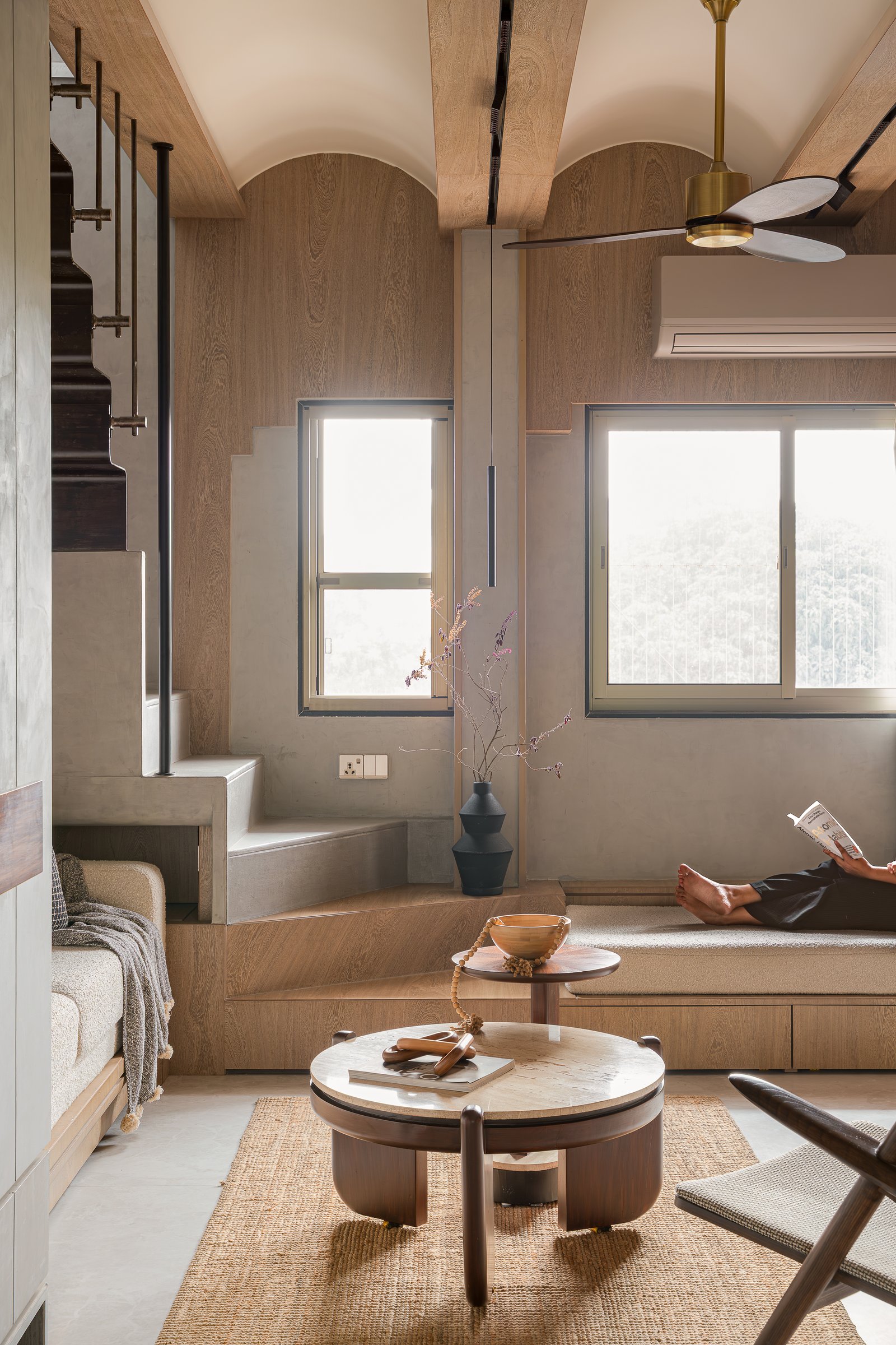 Shallow vaulted arches in wood-grain panelling soften the living room's ceiling into something gentler than a slab
