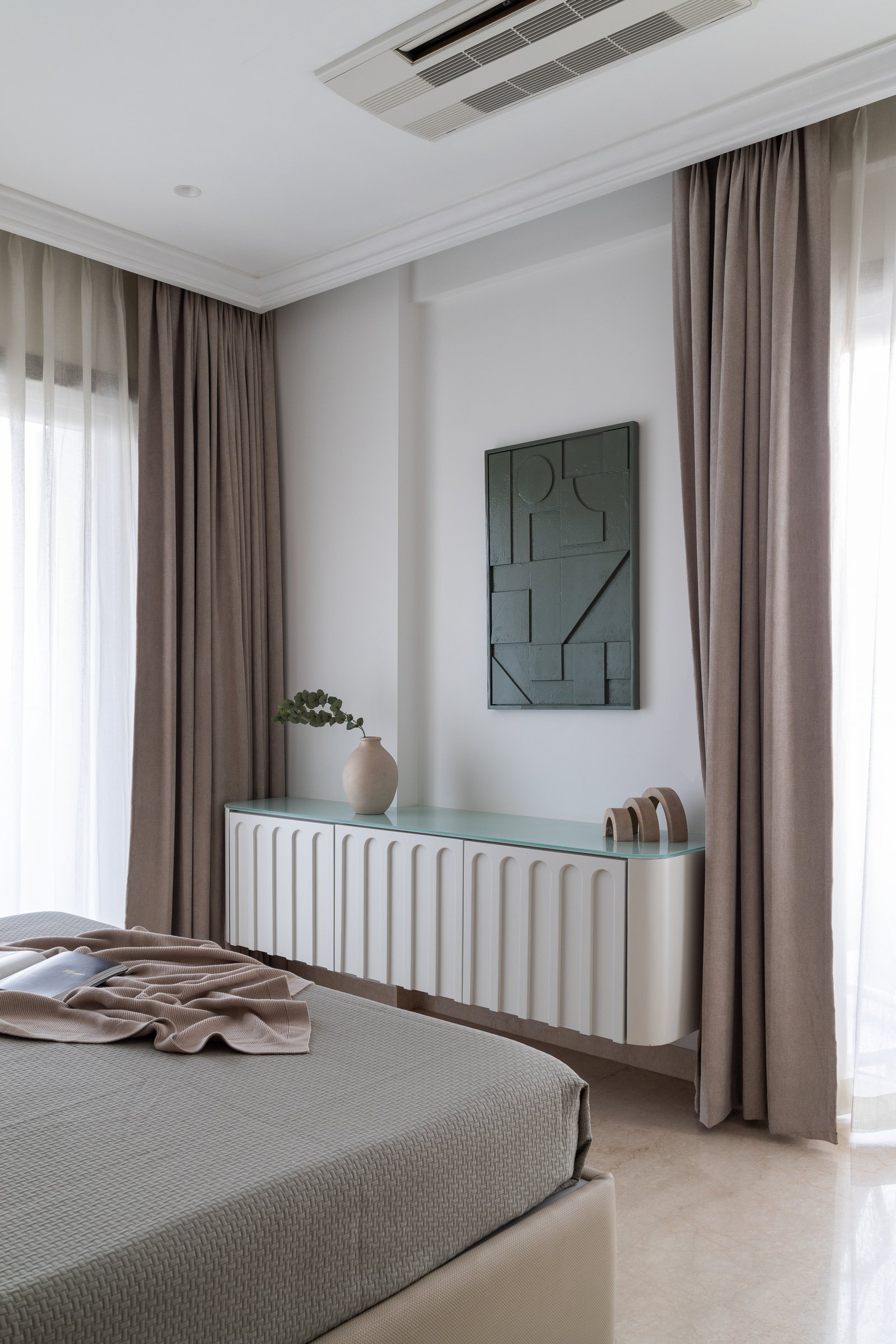 On the opposite wall, a fluted cream console reinterprets a classical motif in a contemporary register