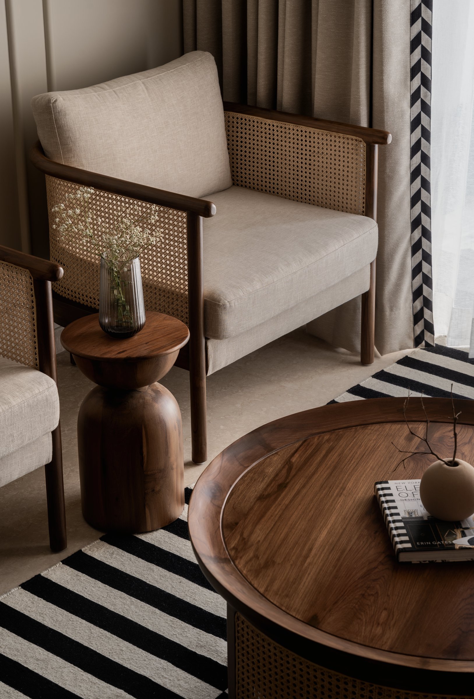 The seating arrangement in detail: cane, turned wood, and walnut staging the case for tactile materials over decorative ones
