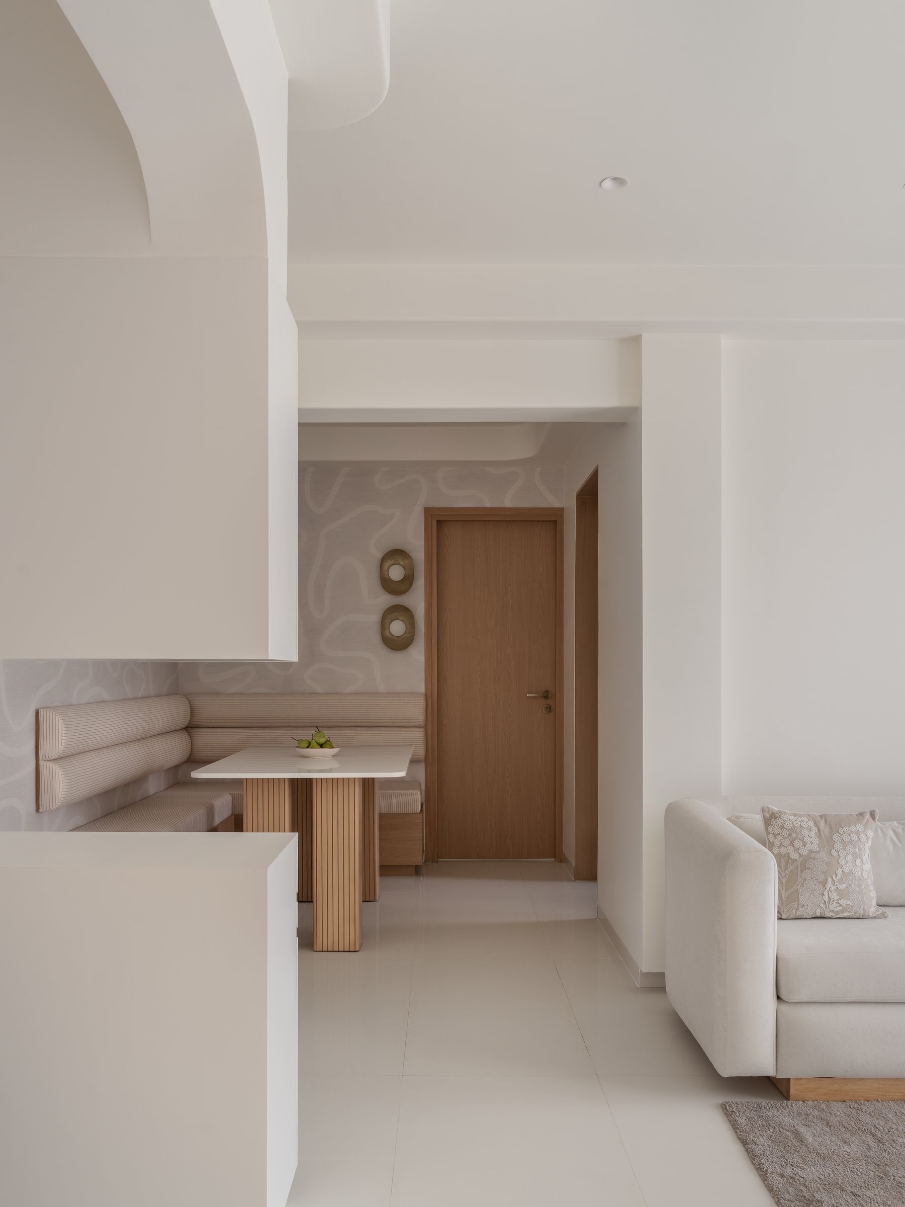 The living and dining zones, sharing one continuous envelope with the looping line-work wallpaper as connective backdrop