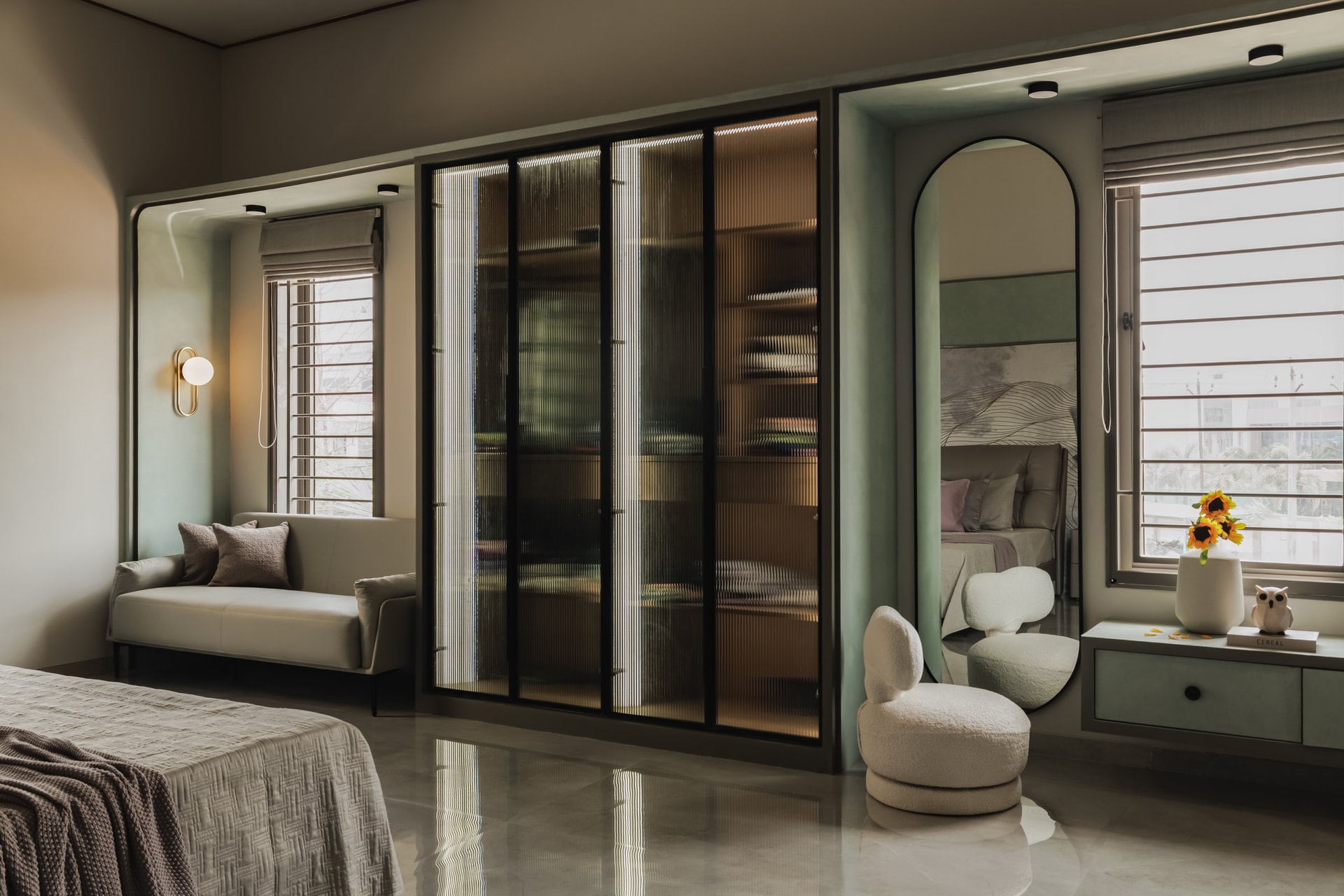 The walk-in closet, where reeded glass doors and an arched dressing alcove turn storage into a private sitting room