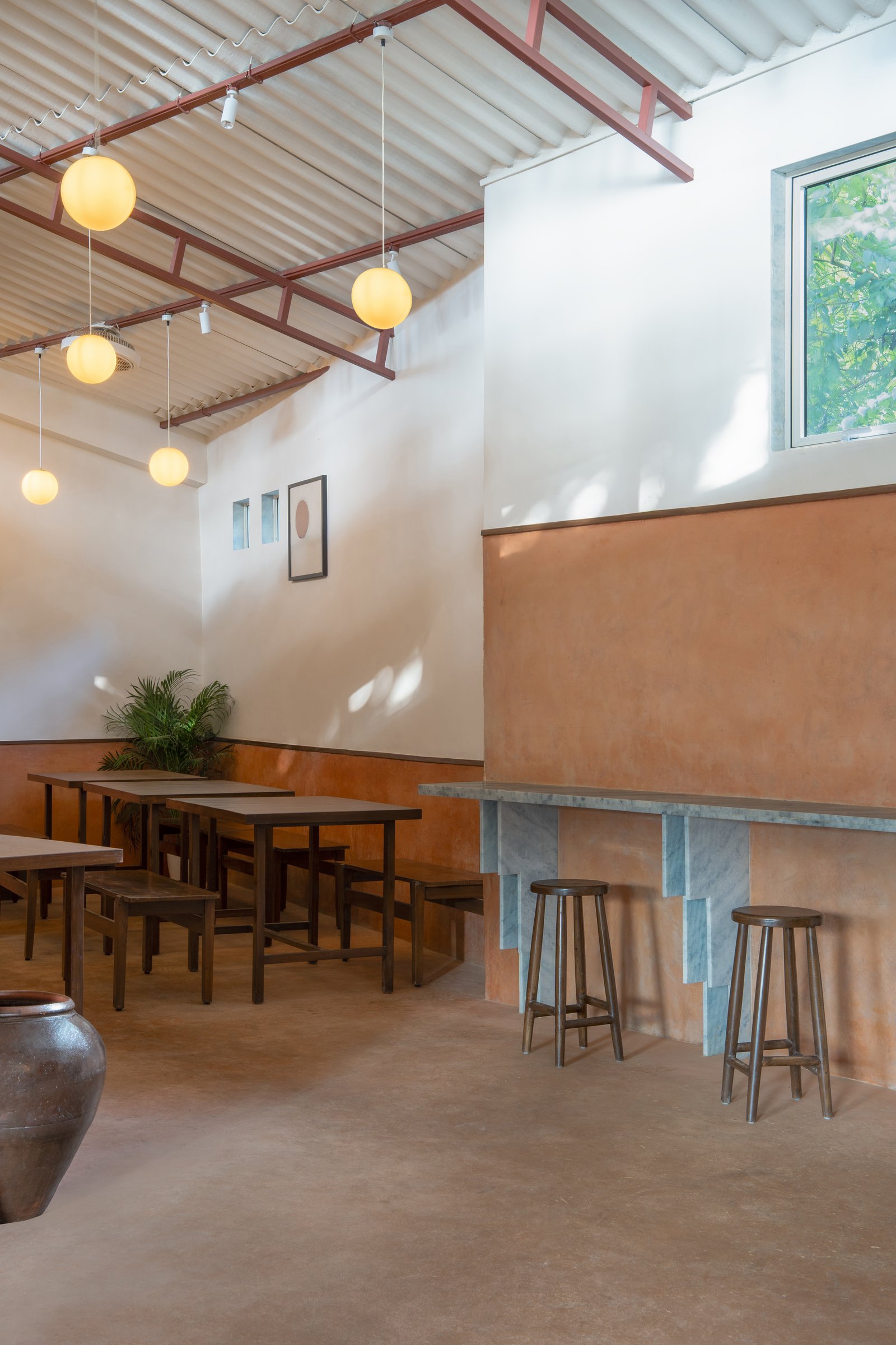 The stepped marble counter that runs along one side of the hall, paired with tall wooden stools