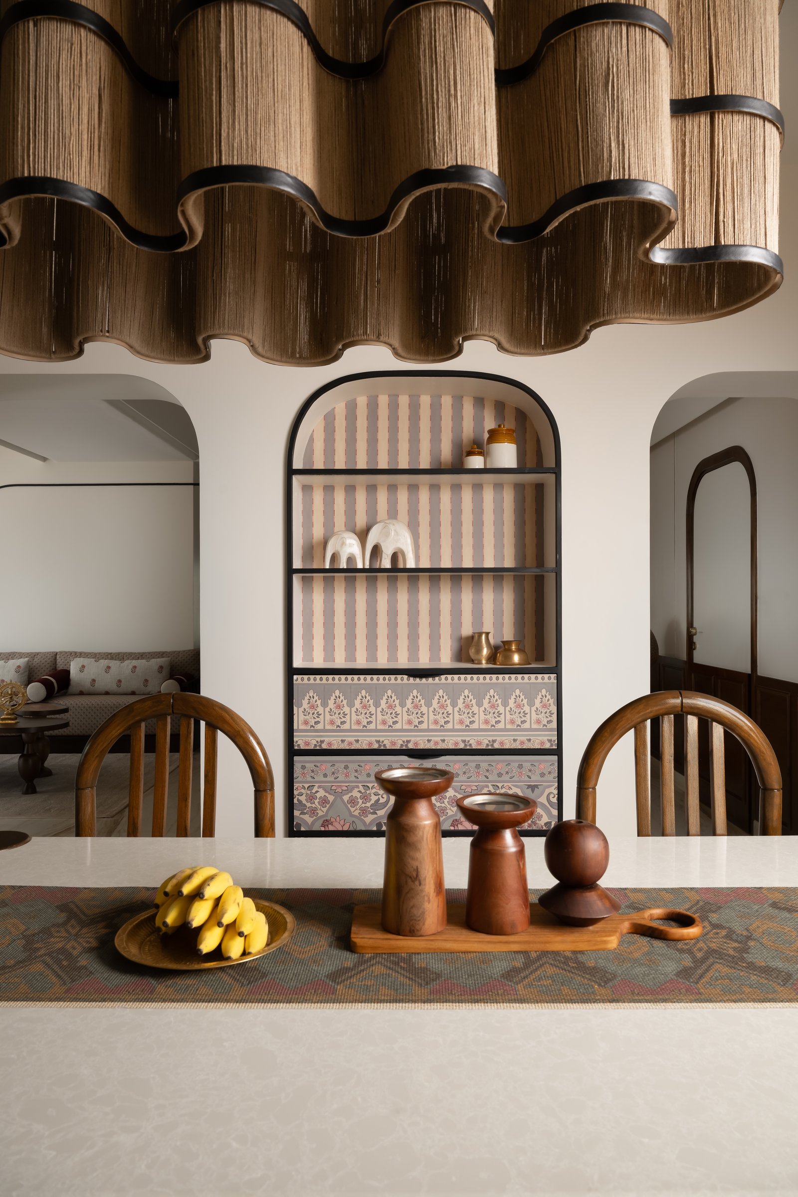 A closer view of the dining room, with its brick-red inlay floor and an arched display niche of brass and ceramics