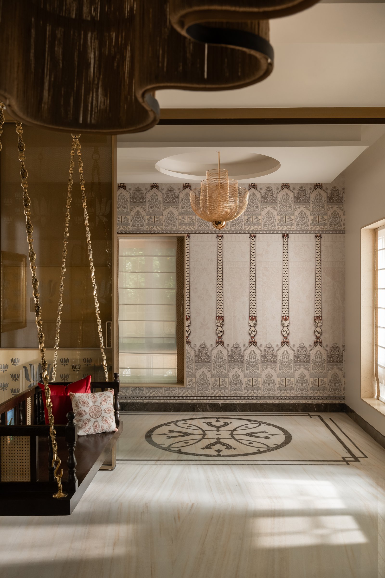 The jhoola alcove, suspended on brass chains against a wallpapered wall with a circular floor inlay below