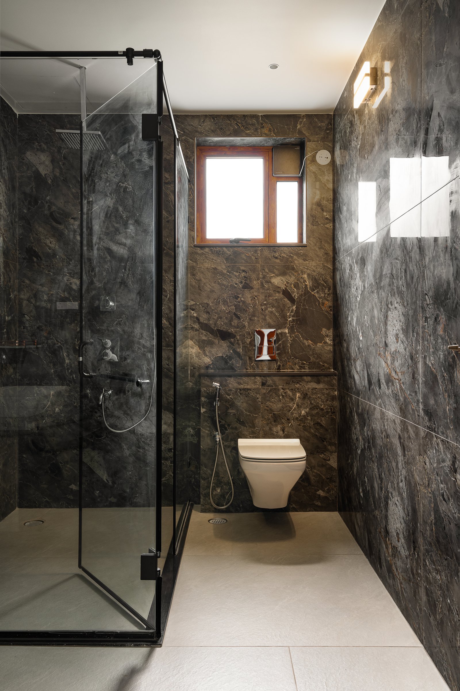 A full shower enclosure carved as a single stone volume, broken only by a small wood-framed window