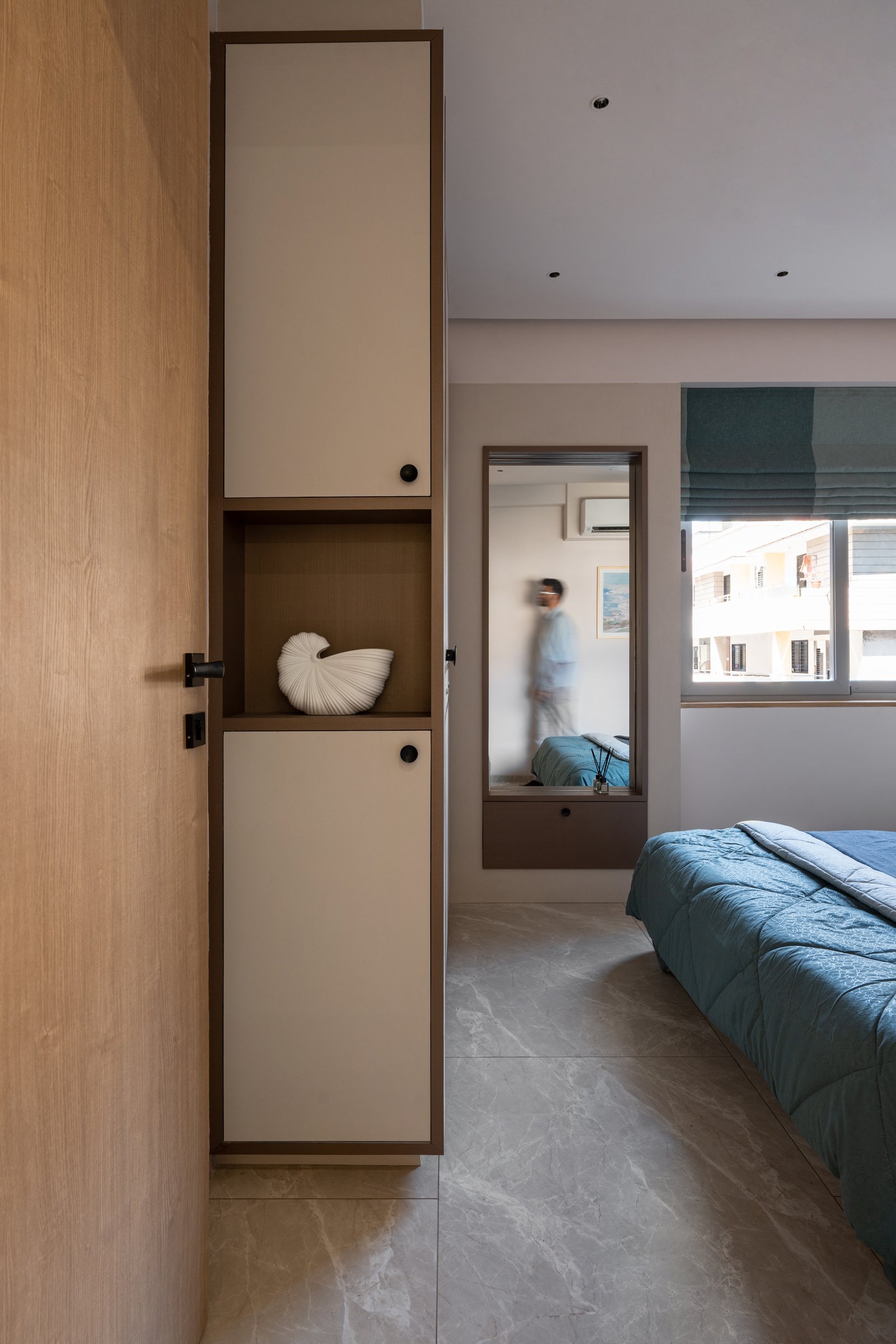 A second view of the same bedroom, where the lower wood band and upper pale wall lend the compact room calm proportion