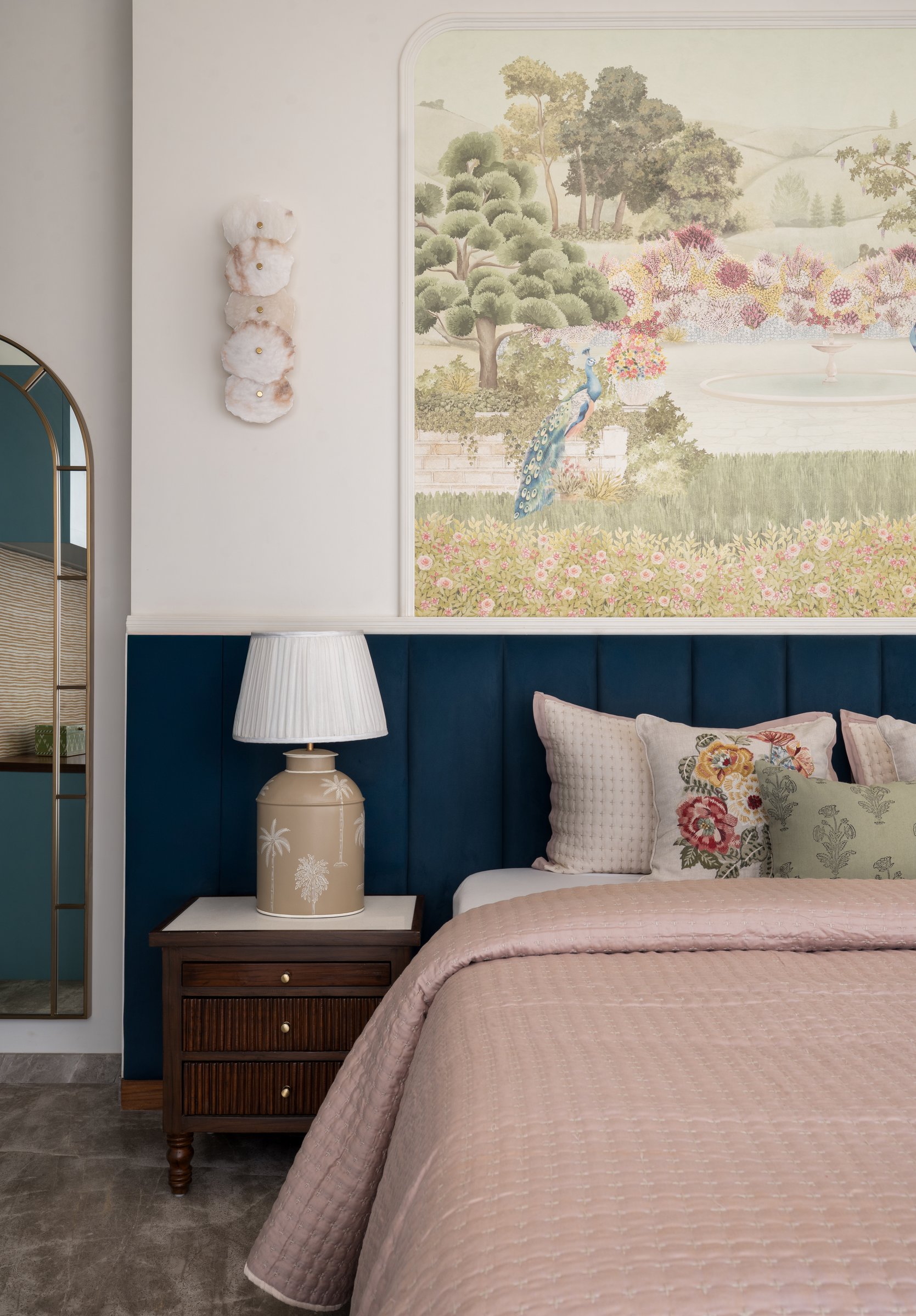 The guest bedroom: a mural wallpaper of a pastoral garden above a deep blue channelled headboard