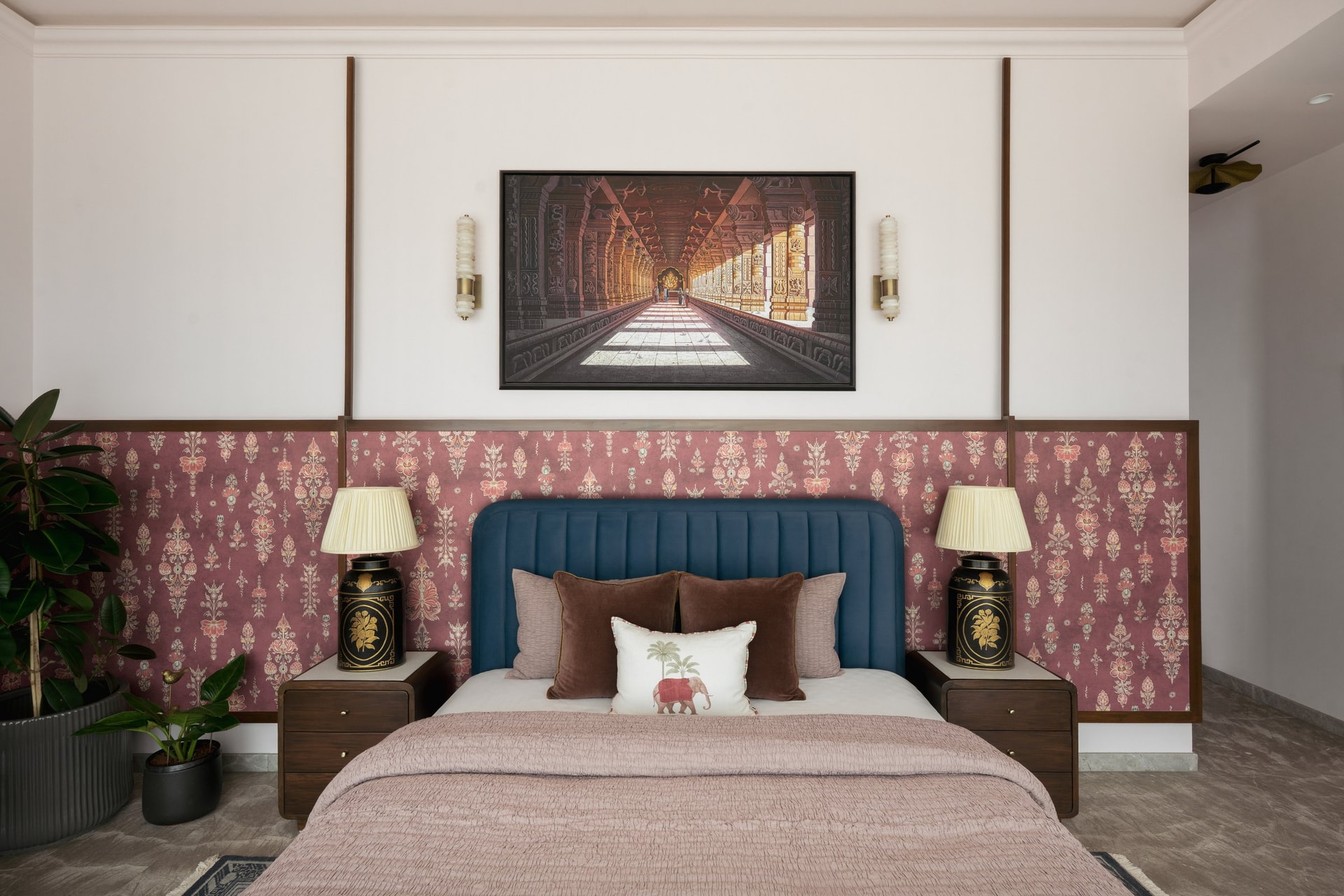 The master bedroom: a blue channelled headboard against pink buti-printed wallpaper, capped at dado height