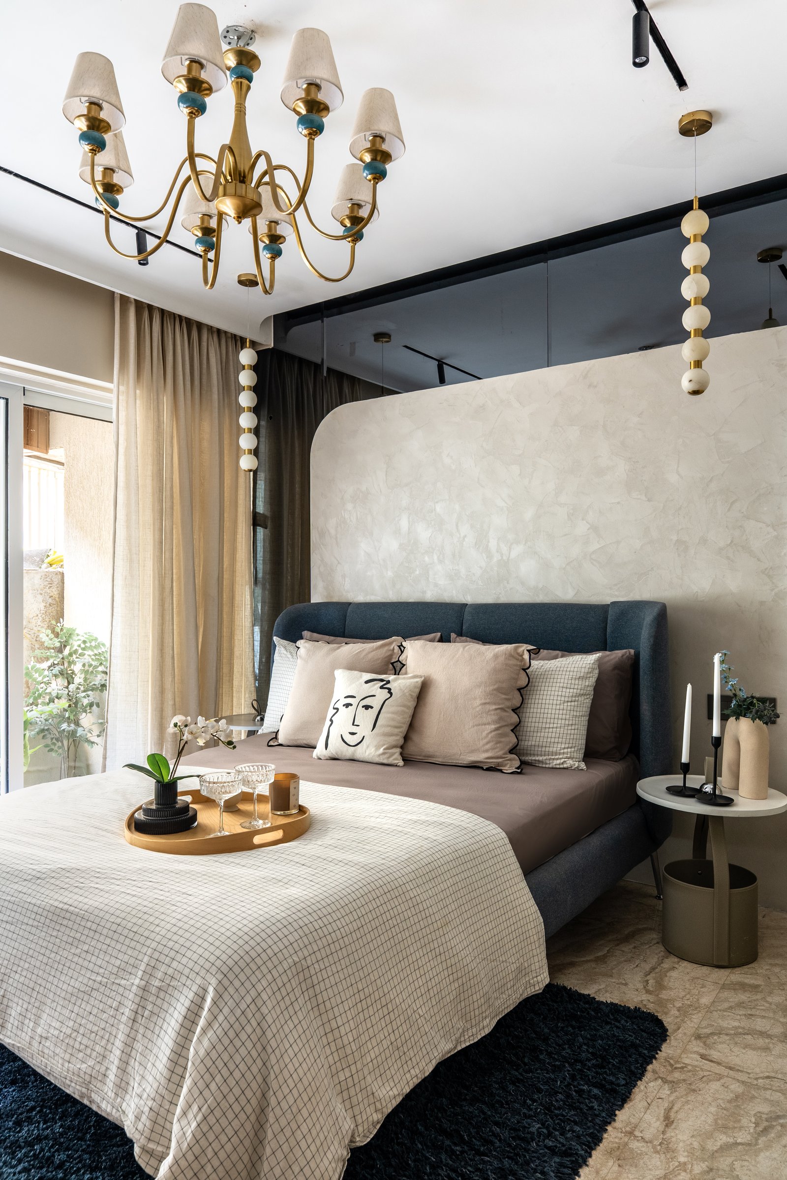 The principal bedroom, where a curved plaster headboard wall meets a deep teal bed in composed restraint