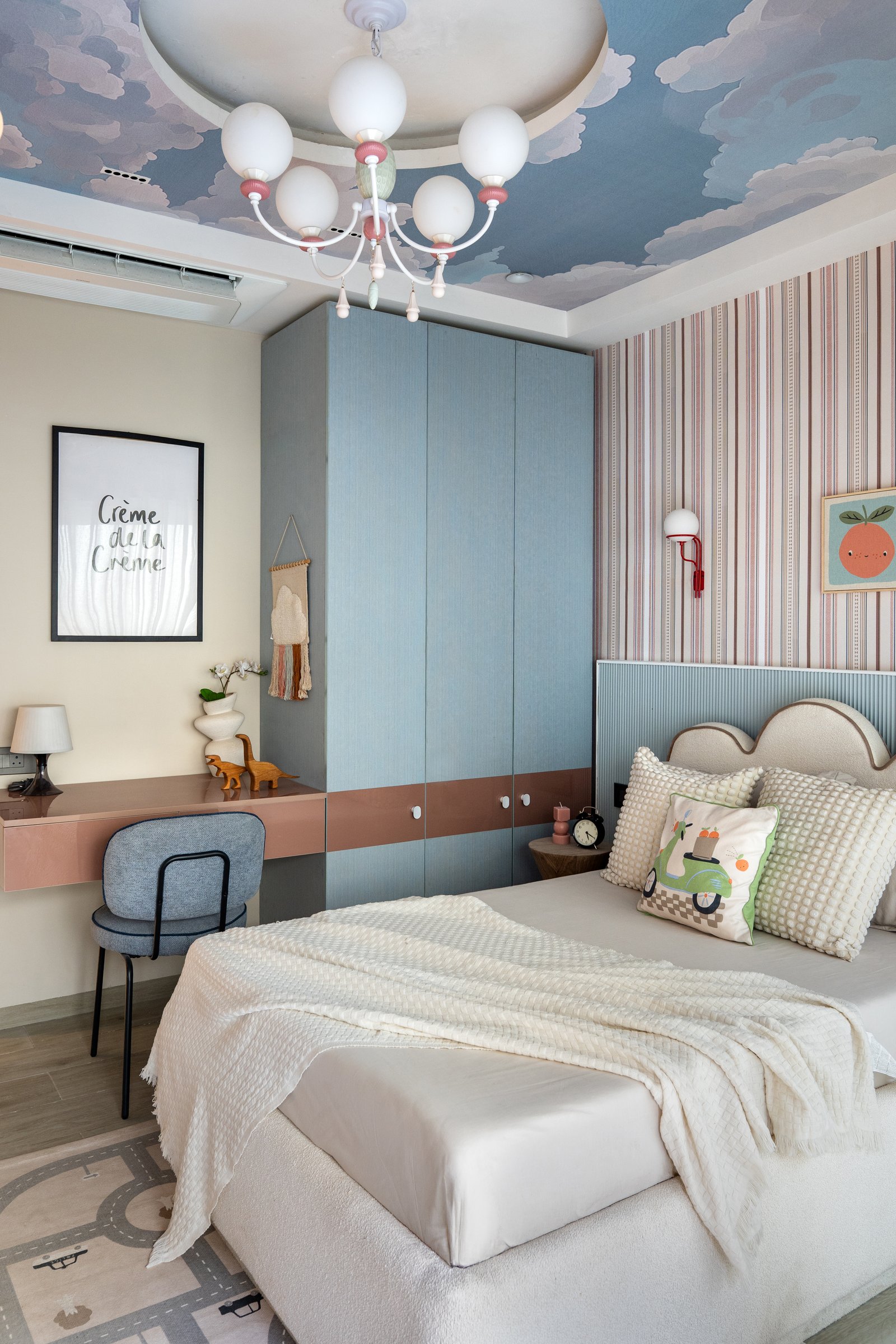 The children's bedroom, where a painted cloudscape ceiling meets striped walls and a scalloped headboard