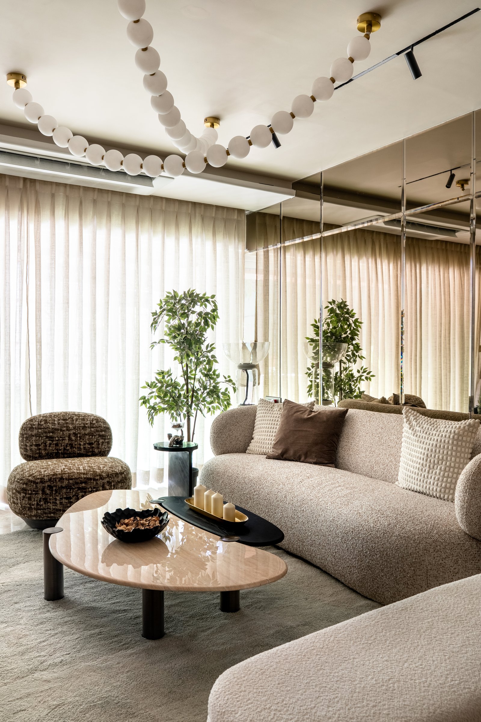 The seating area, where a sculptural orb pendant traces an architectural drawing in light across the ceiling