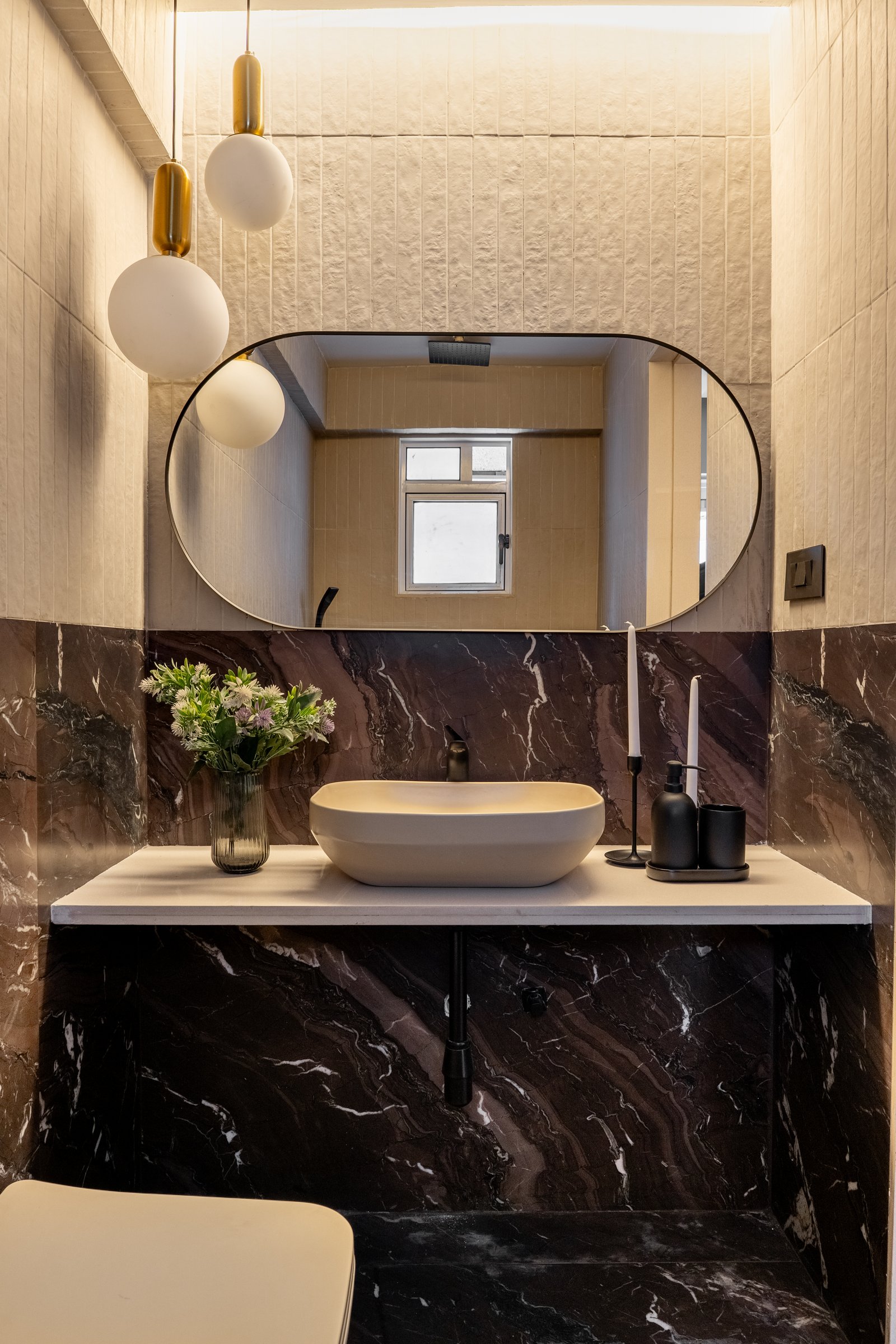 The third bathroom, where deep oxblood-veined stone lends powder-room formality to a utilitarian space