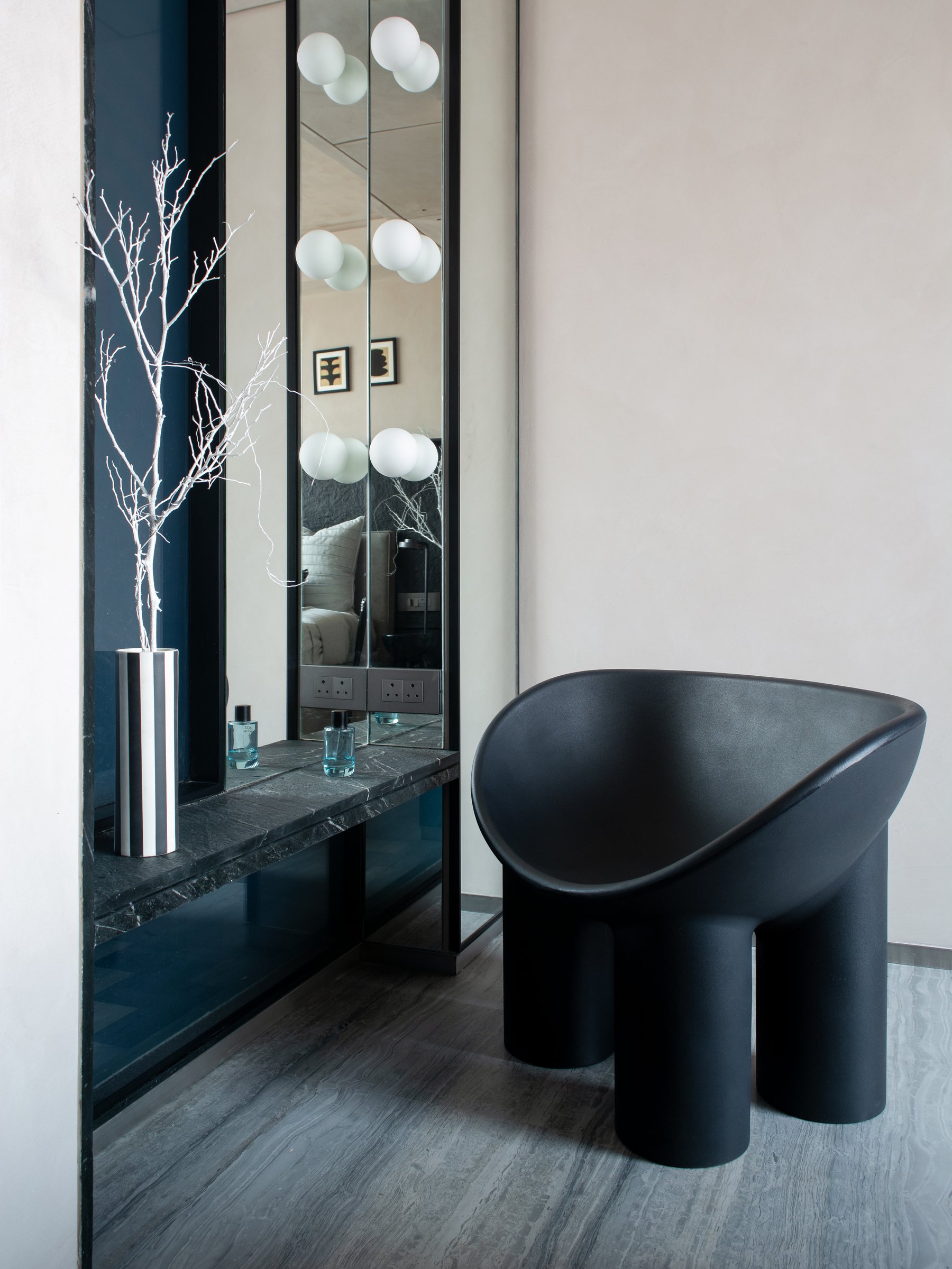 The adjoining dressing corner, where a dark stone counter is set between mirrored vertical panels