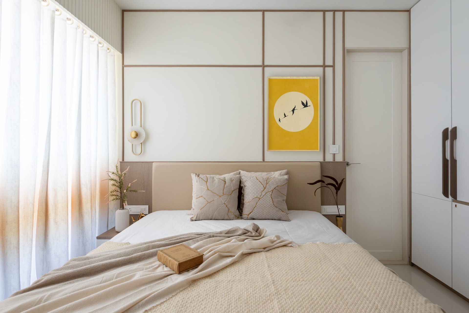 The master bedroom, where a grid of fine mouldings frames the headboard wall in a quiet architectural rhythm