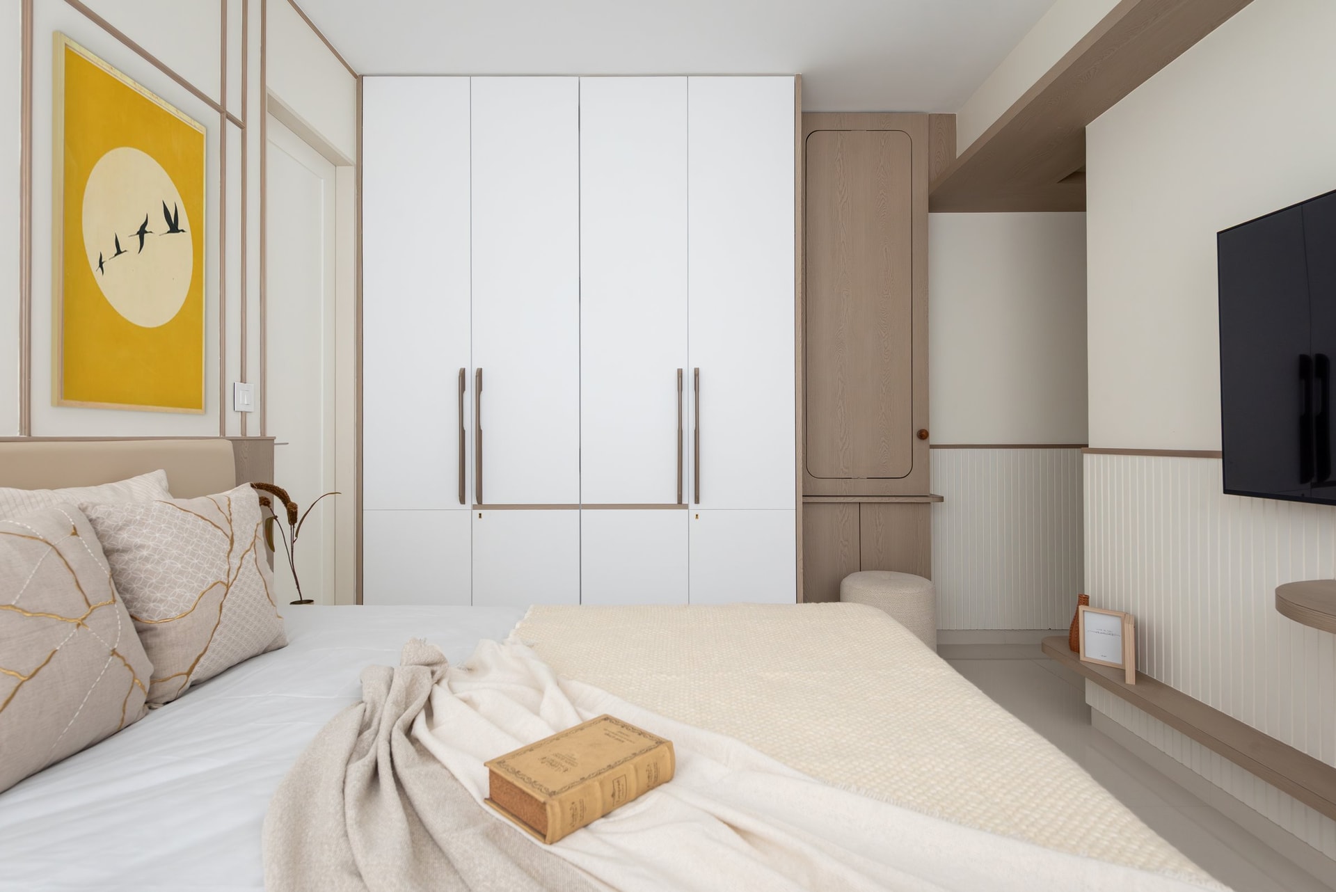 Across the master bedroom, storage and technology align within one continuous architectural line