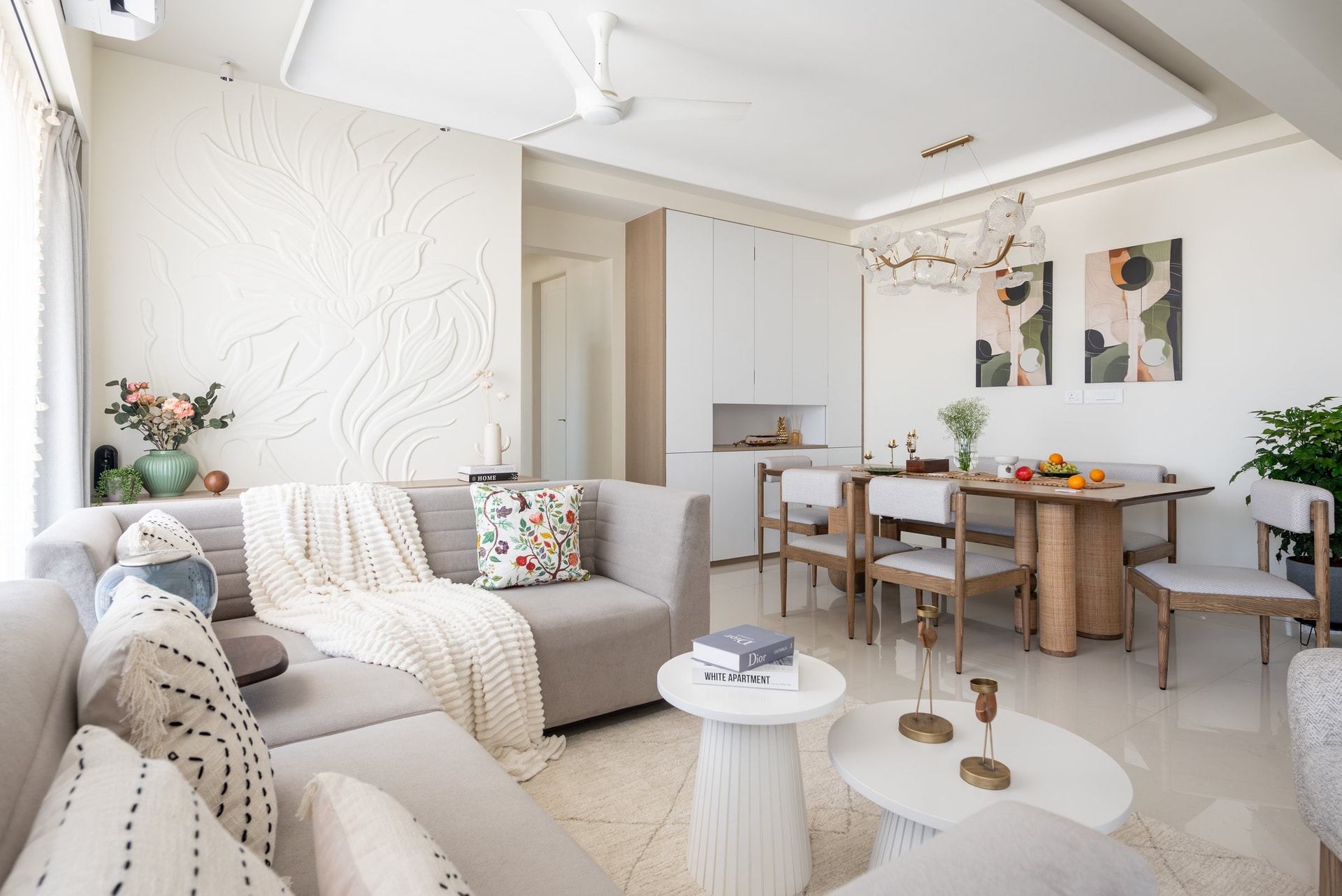The living room, where a sculptural plaster relief in tonal white anchors the seating without raising the visual register