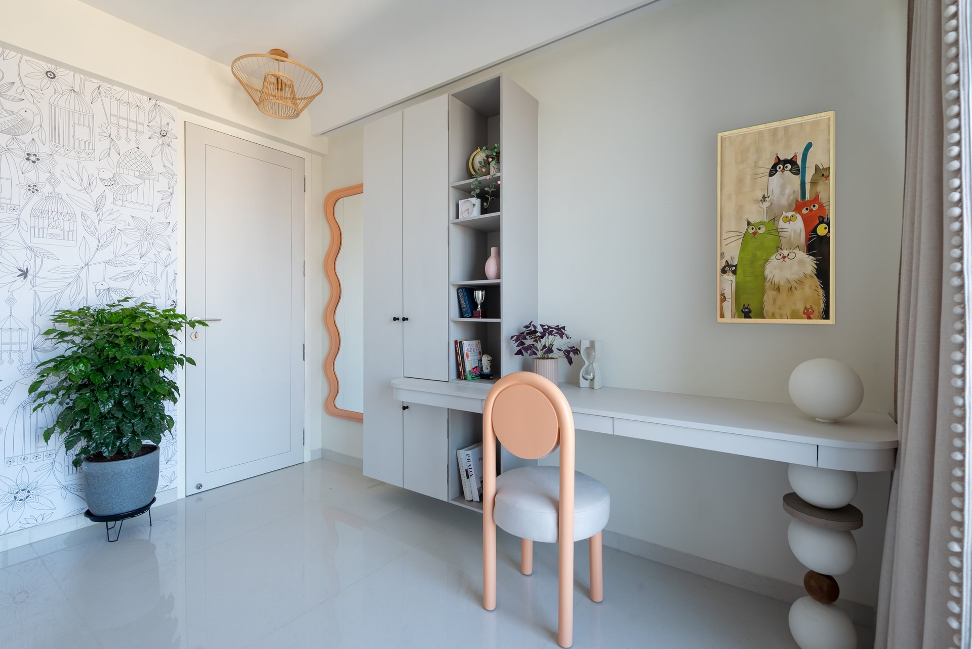 A study and dressing corner within the children's room, where a line-drawn wallpaper and peach accents introduce a playful register