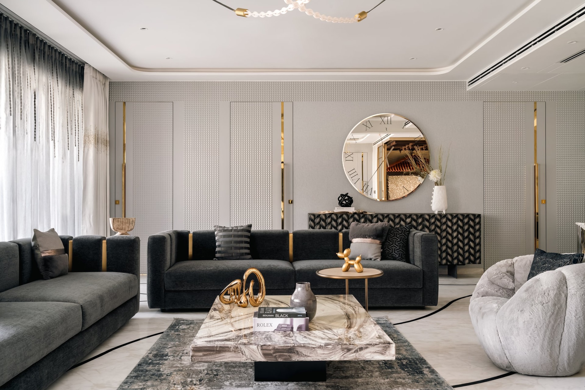 In the living room, textured grey panelling and slim brass inlays provide the calm grid against which the maximalism is staged