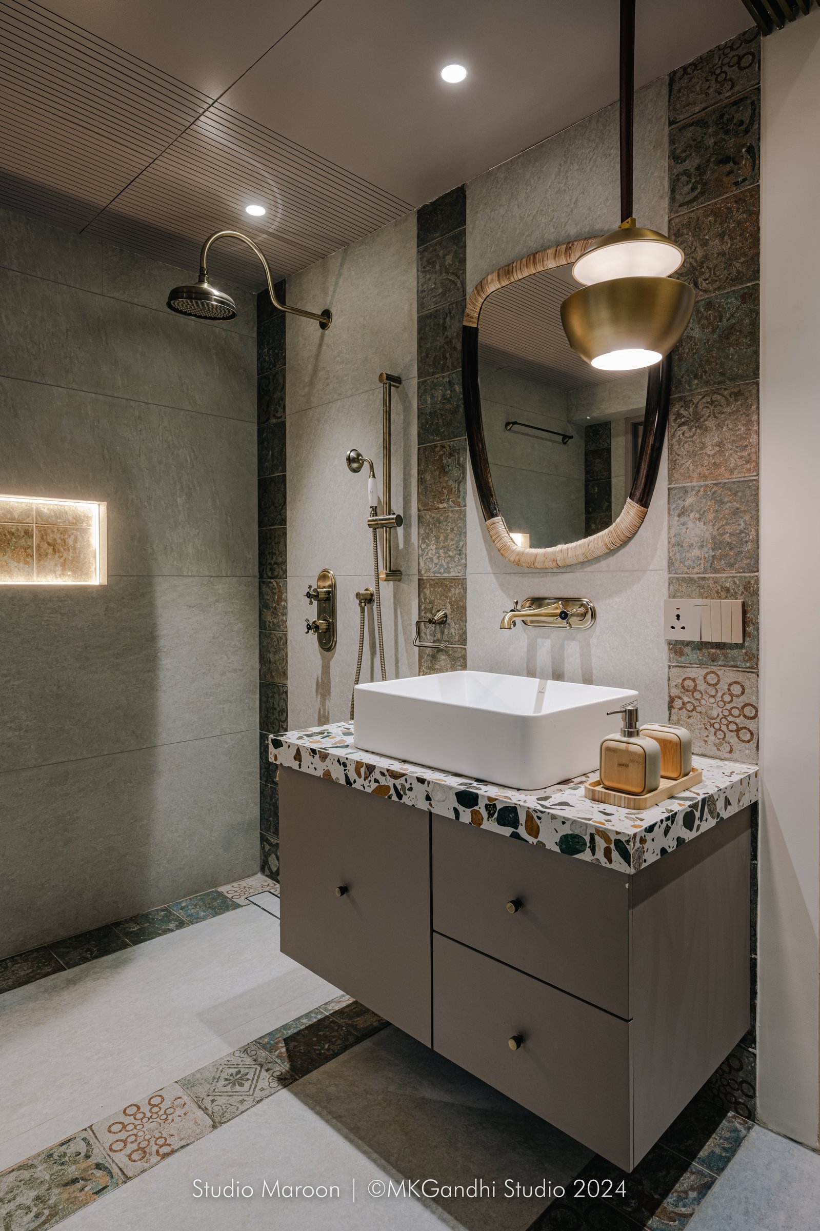 The master bath shifts toward cool greys and patterned encaustic-style tile, with the terrazzo vanity creating continuity across the home