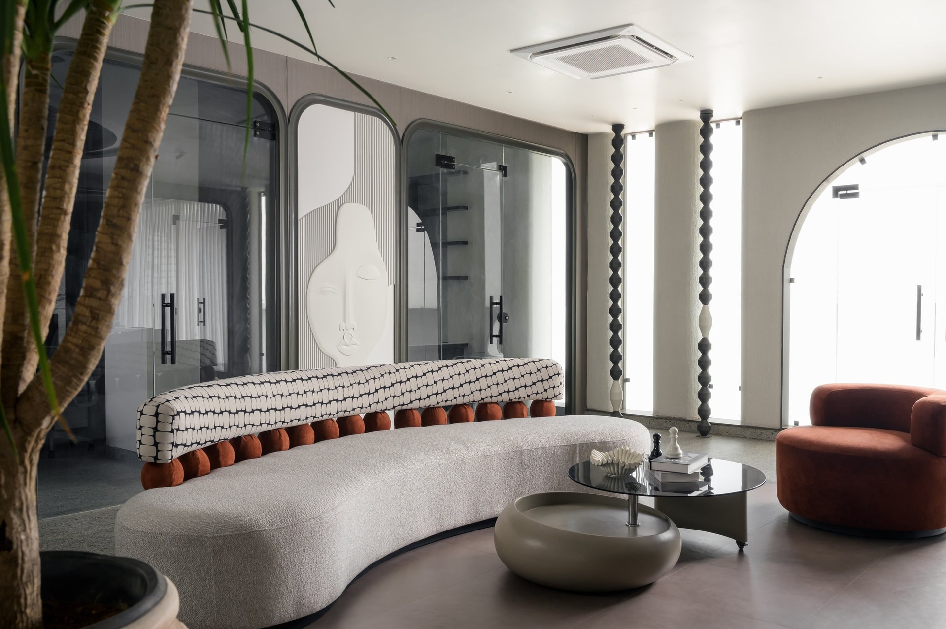 The lounge seen from within, where a low plaster relief anchors a room otherwise defined by movement