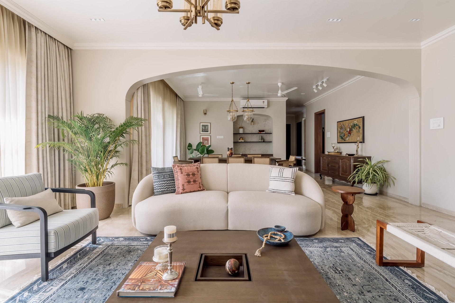 The living room, framed by an arched opening that holds the entire social volume in a single view